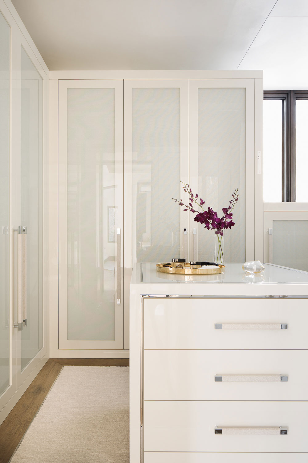 Red Mountain - Creamy white walk-in closet with opaque glass doors and center island. Interior...