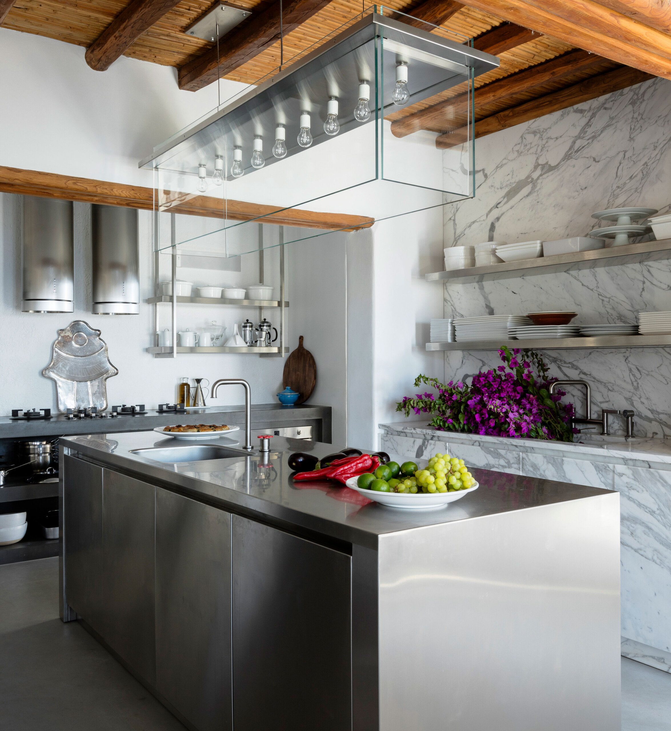 Cycladic Villa - Scandinavian-inspired kitchen with white marble and stainless steel island, shelving,...