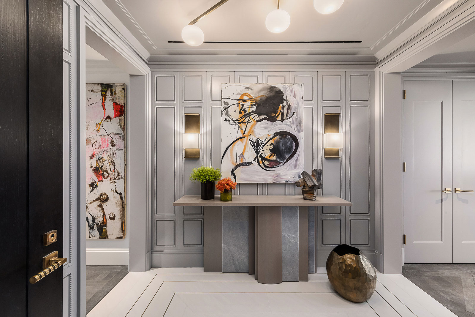 1010 Park Avenue - Entryway of New York home featuring stone console table, glass wall sconces,...