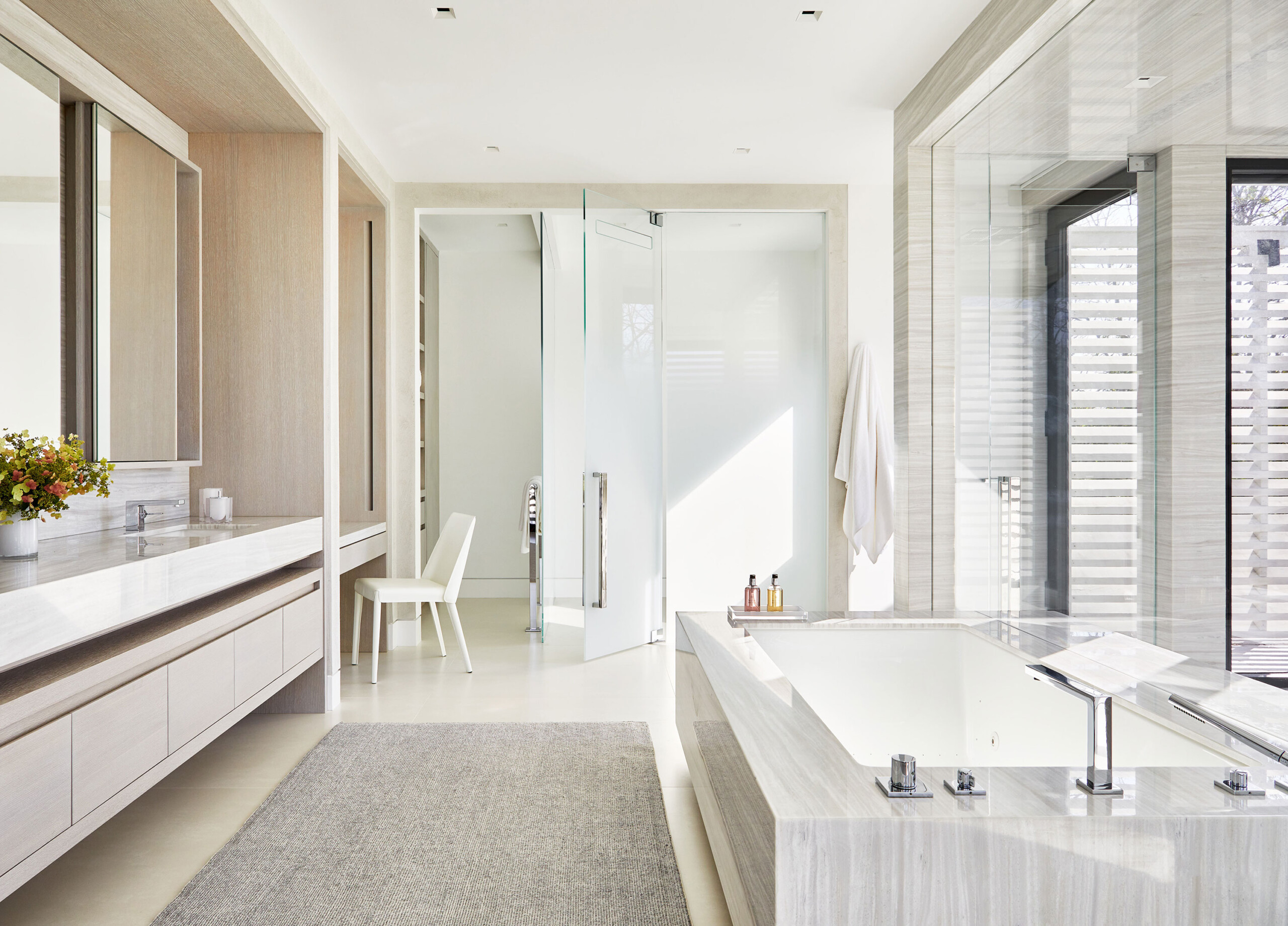 Southampton Estate - Pembrooke & Ives - White and neutral modern bathroom with stone tub and vanity....
