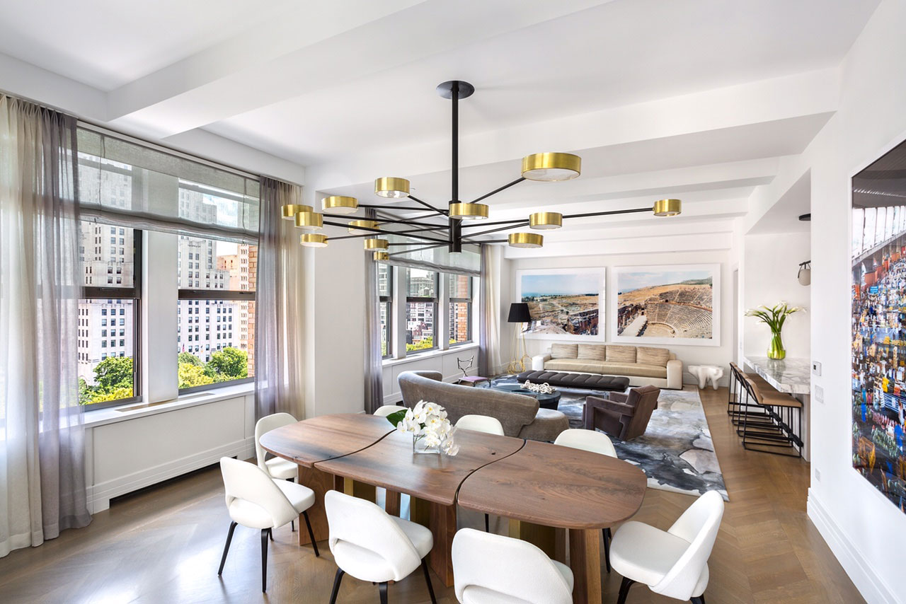 212 Fifth Avenue - Open floor plan in New York condo featuring a rounded dining table below brass...