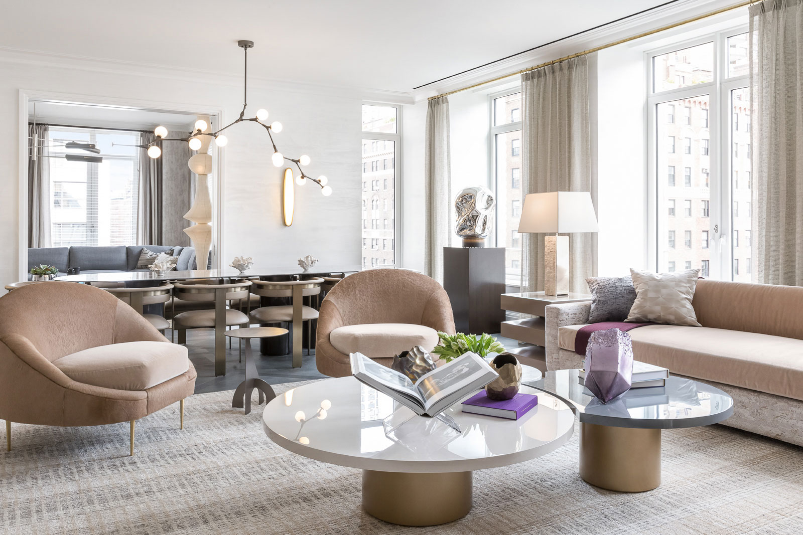 1010 Park Avenue - Modern living room with stone and brass coffee table, taupe accent chairs and...