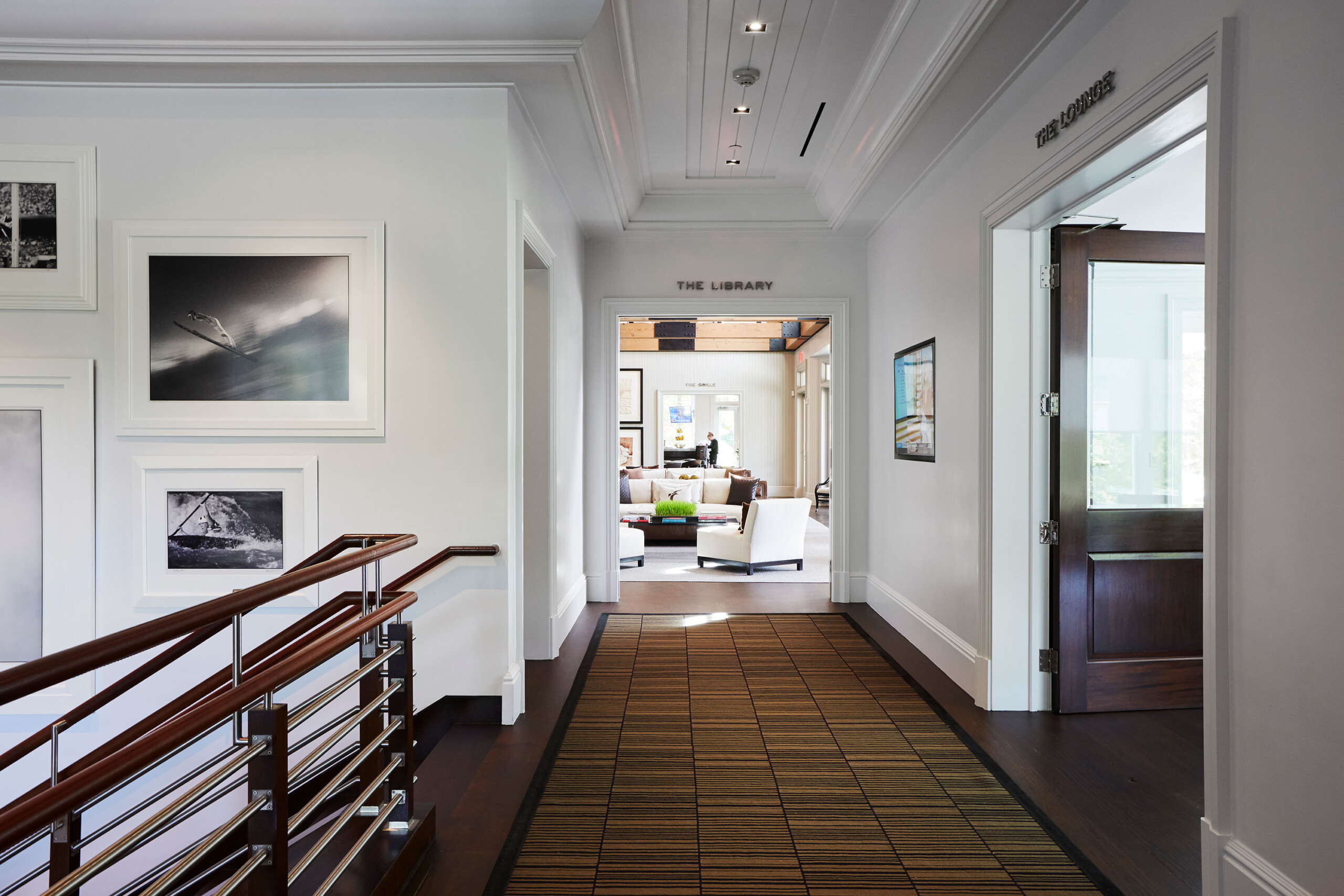 East Hampton Golf Club - Hallway of East Hampton golf club with crown moulding, wayfinding signage,...