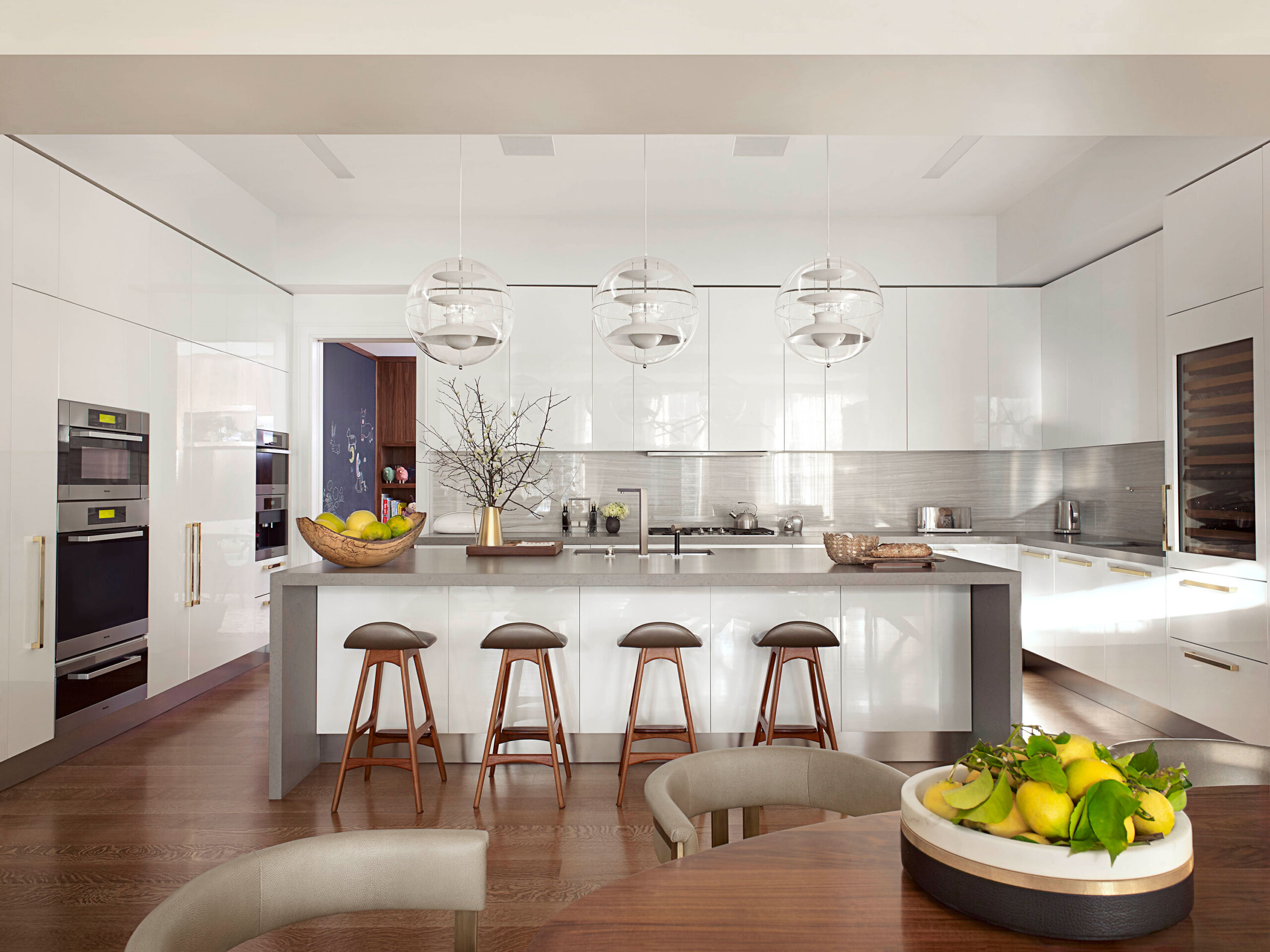 Madison Square Park - Modern kitchen in NYC apartment featuring whote cabinetry, gray backsplash,...