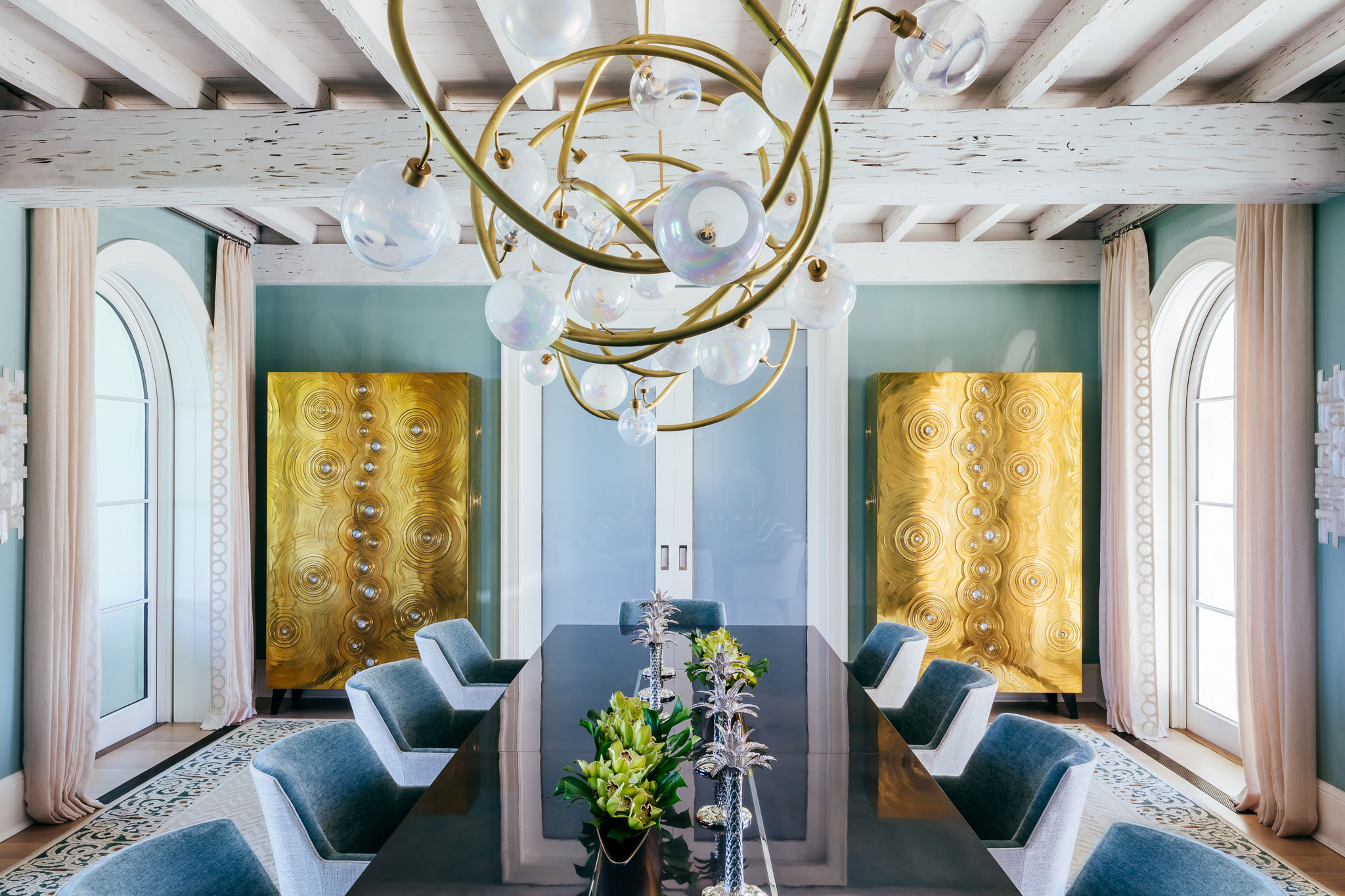 Ocean-front Compound - Luxury coastal dining room with statement brass and opaque glass chandelier,...