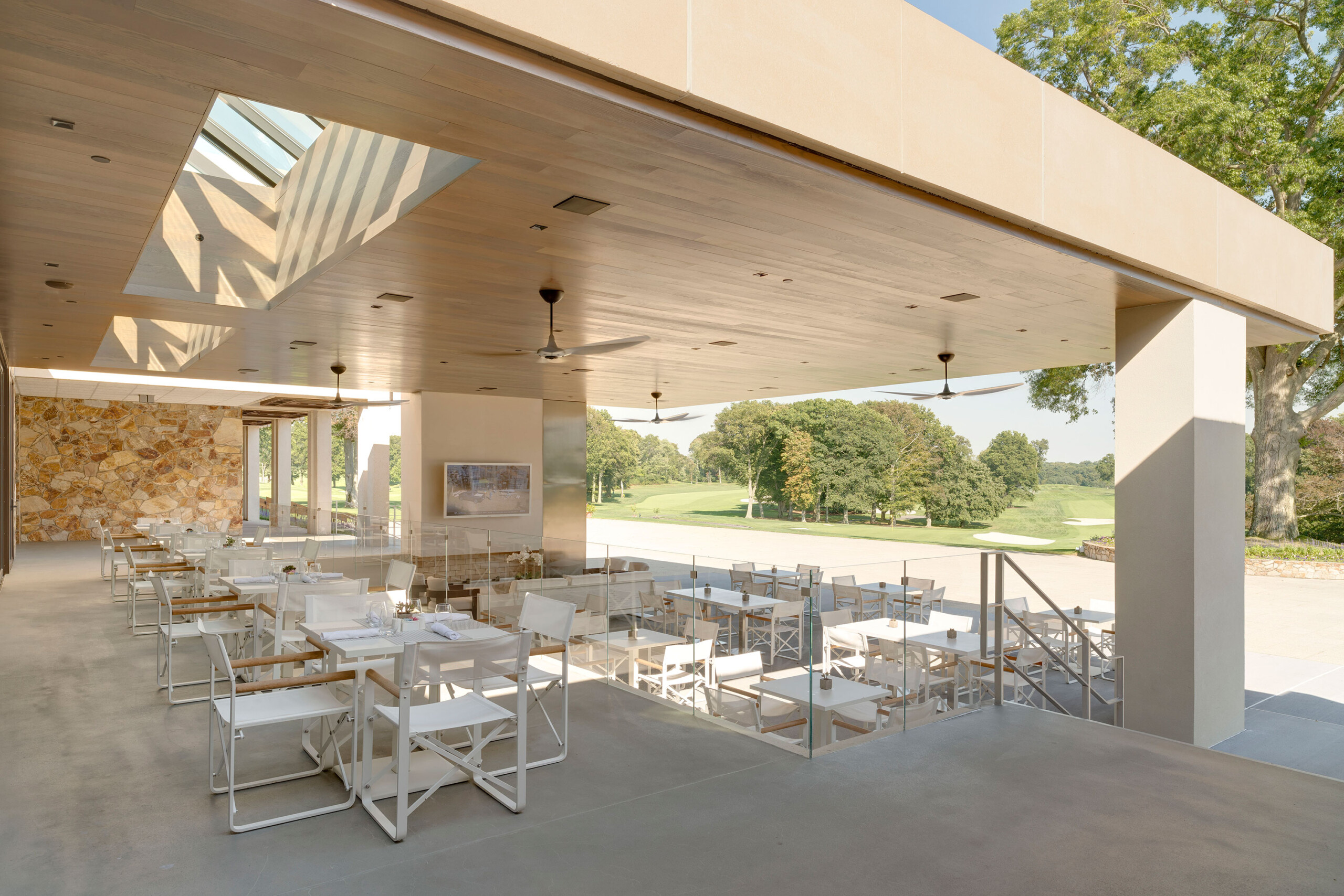 Glen Oaks Club - Outdoor dining area of modern Long Island country club. Hospitality design by...