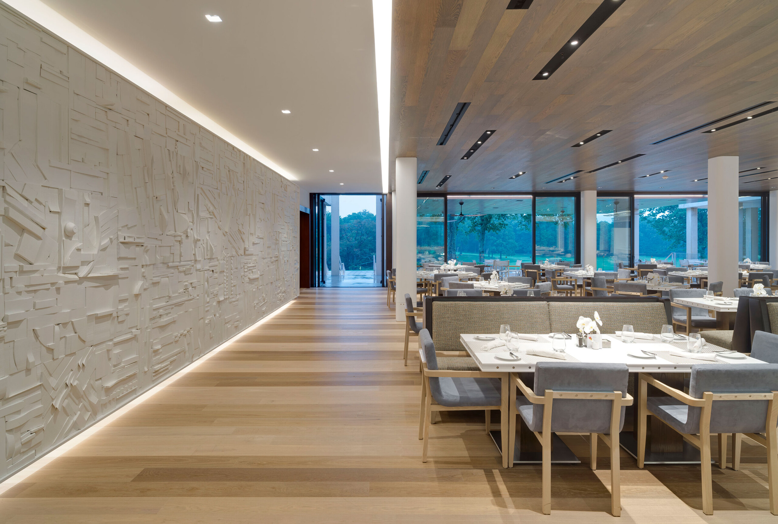 Glen Oaks Club - Modern dining room of Long Island country club with textured wall, cove lighting...