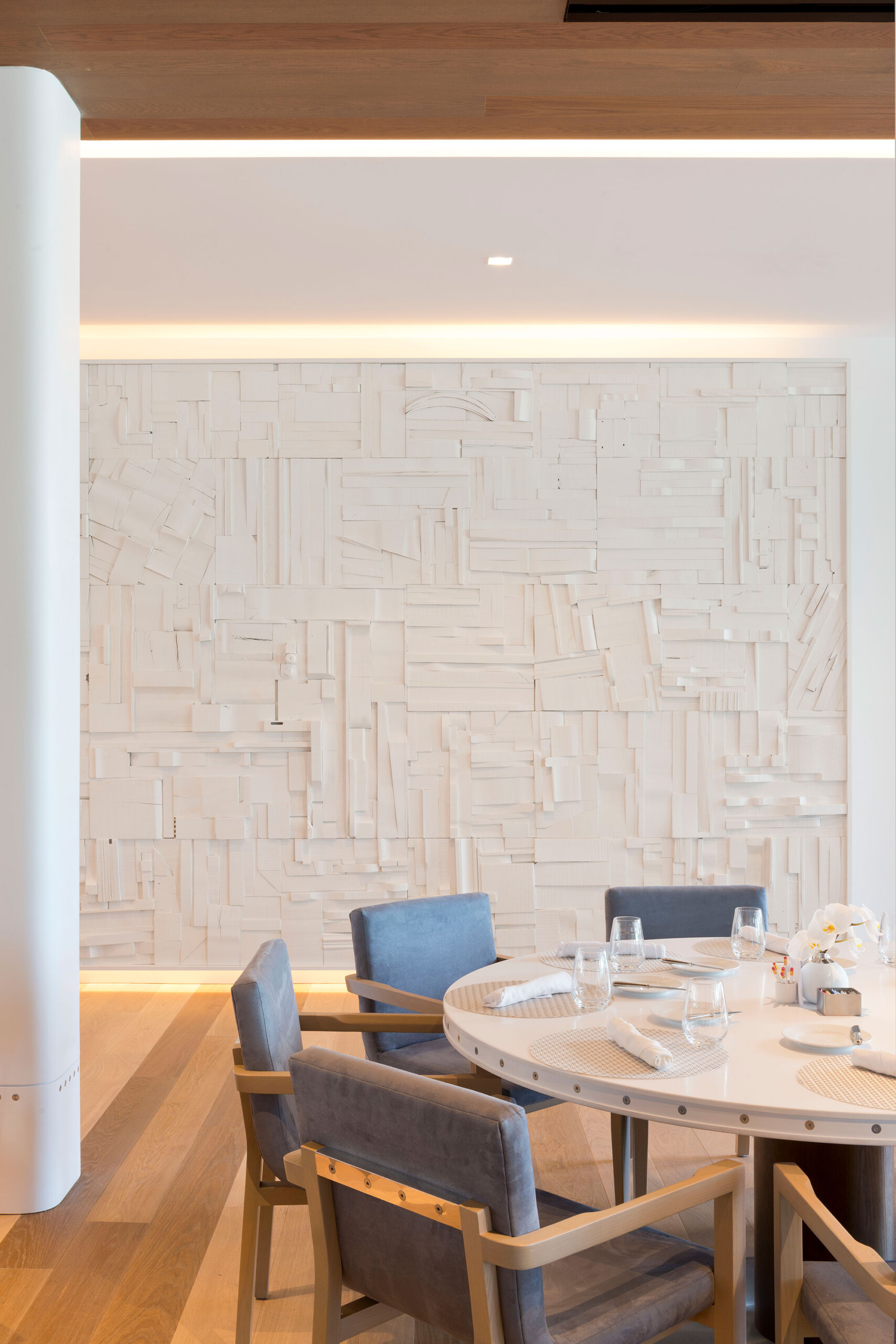 Glen Oaks Club - Textured wall with cove lighting in modern dining room of Long Island country...