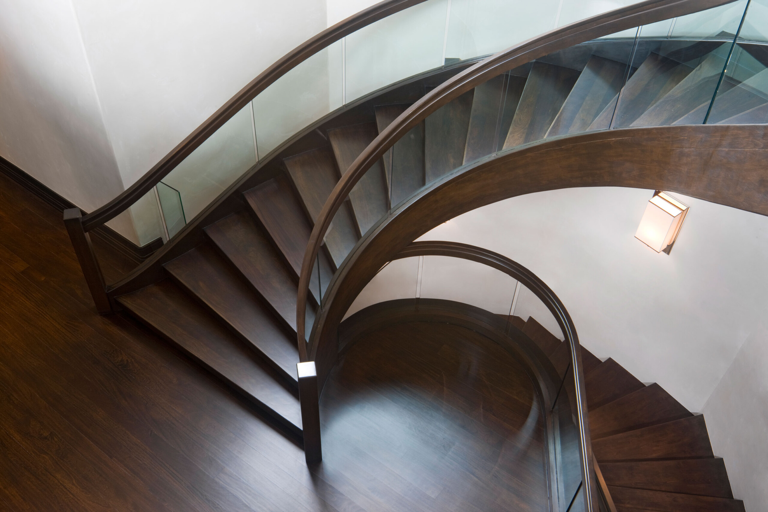 Willoughby Way - Luxury transitional spiral staircase with dark wood and white elements and glass...