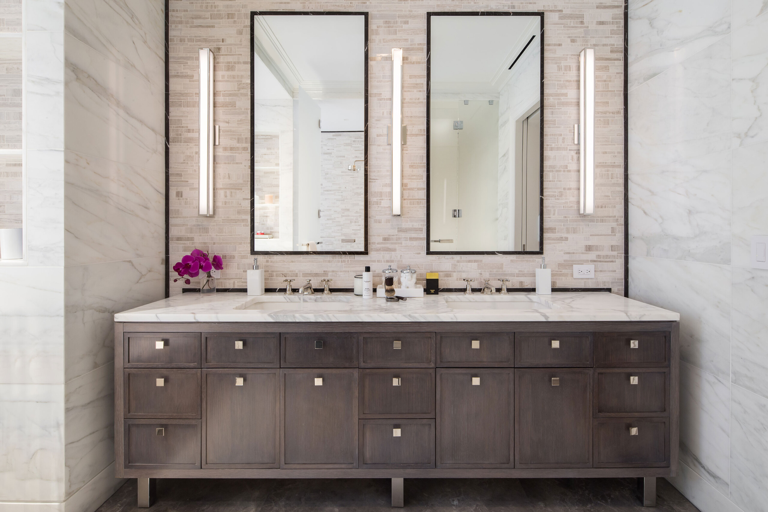The Astor - Modern bathroom vanity with double mirror and sink featuring white marble and accent...