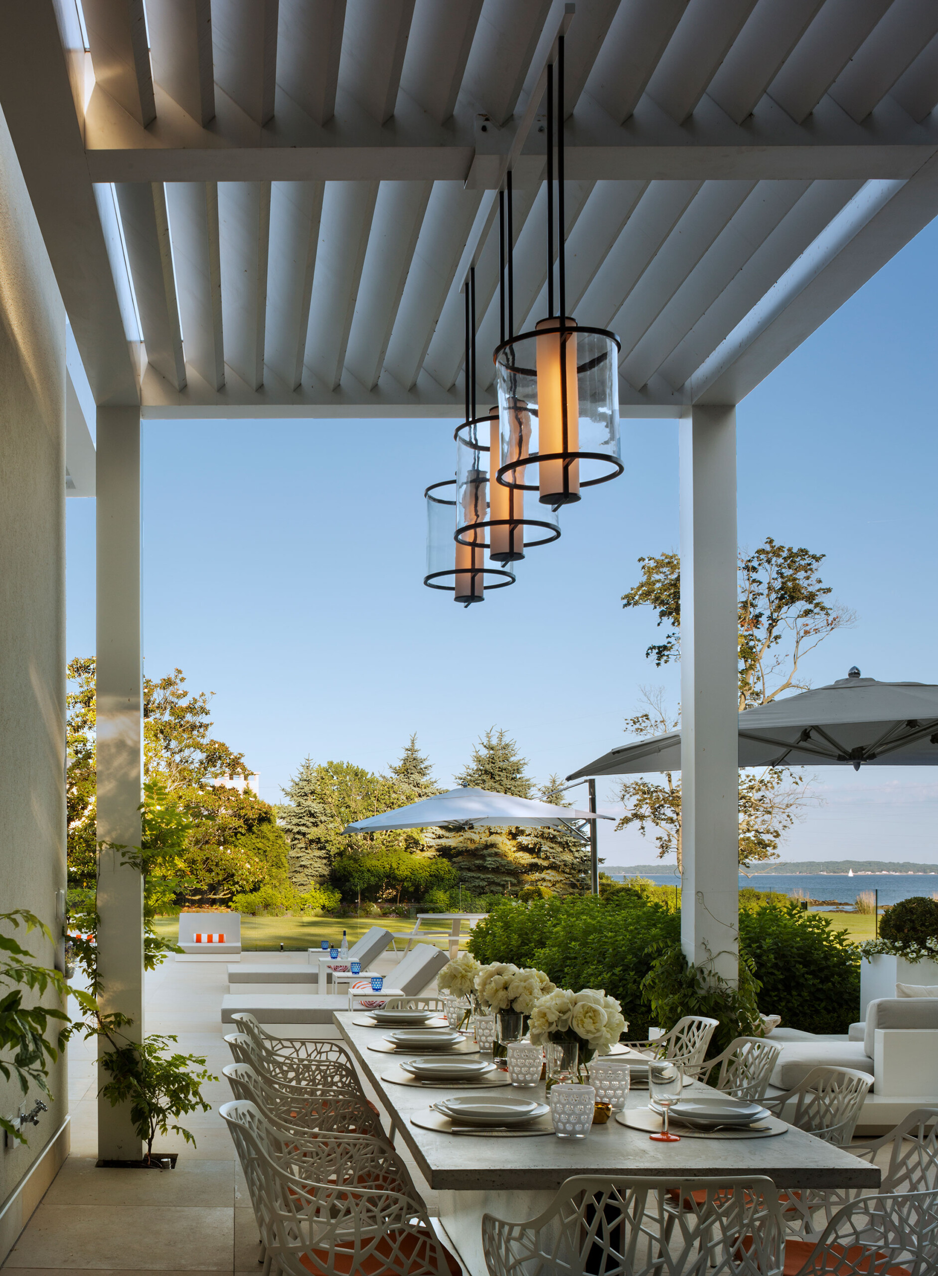 Rye Pool House - Patio dining area of modern luxury pool house, featuring contemporary glass lantern...