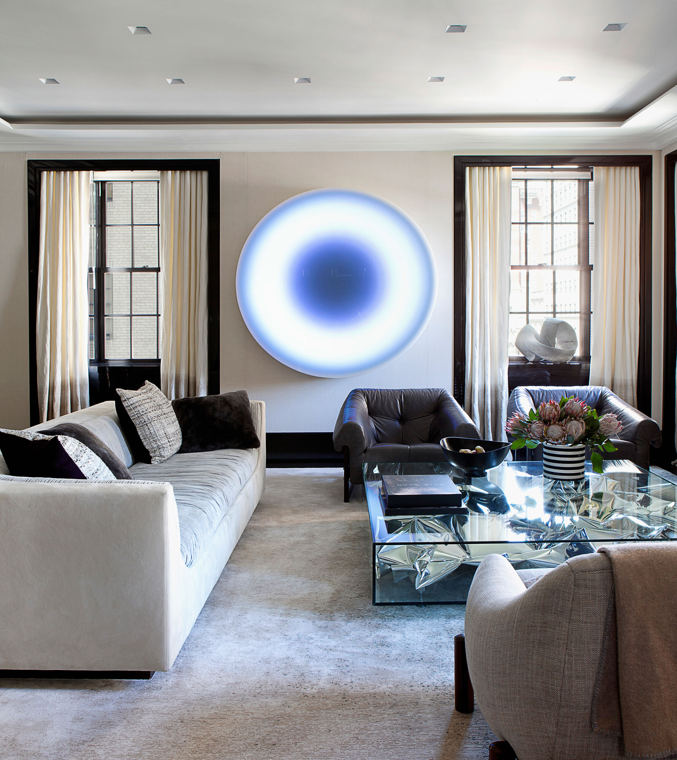 Glamour on Park - Living room design in Park Avenue home with statement art, glass coffee table,...