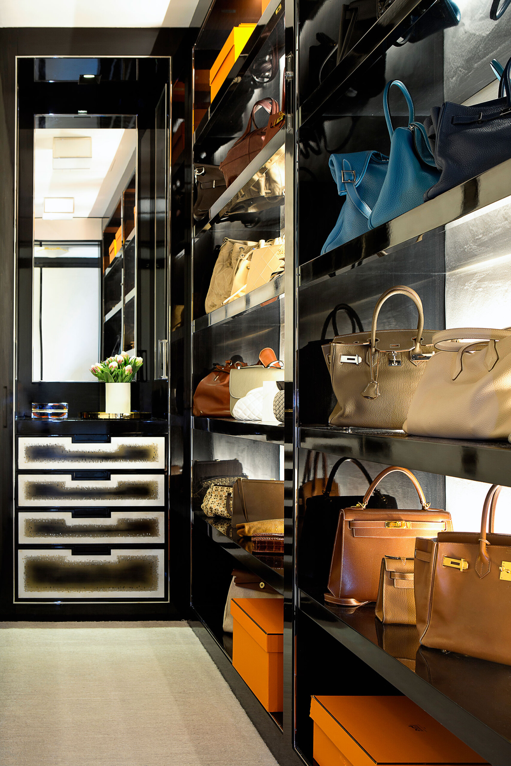 Glamour on Park - Luxury walk-in closet featuring glossy black and chrome finishes. Interior design...