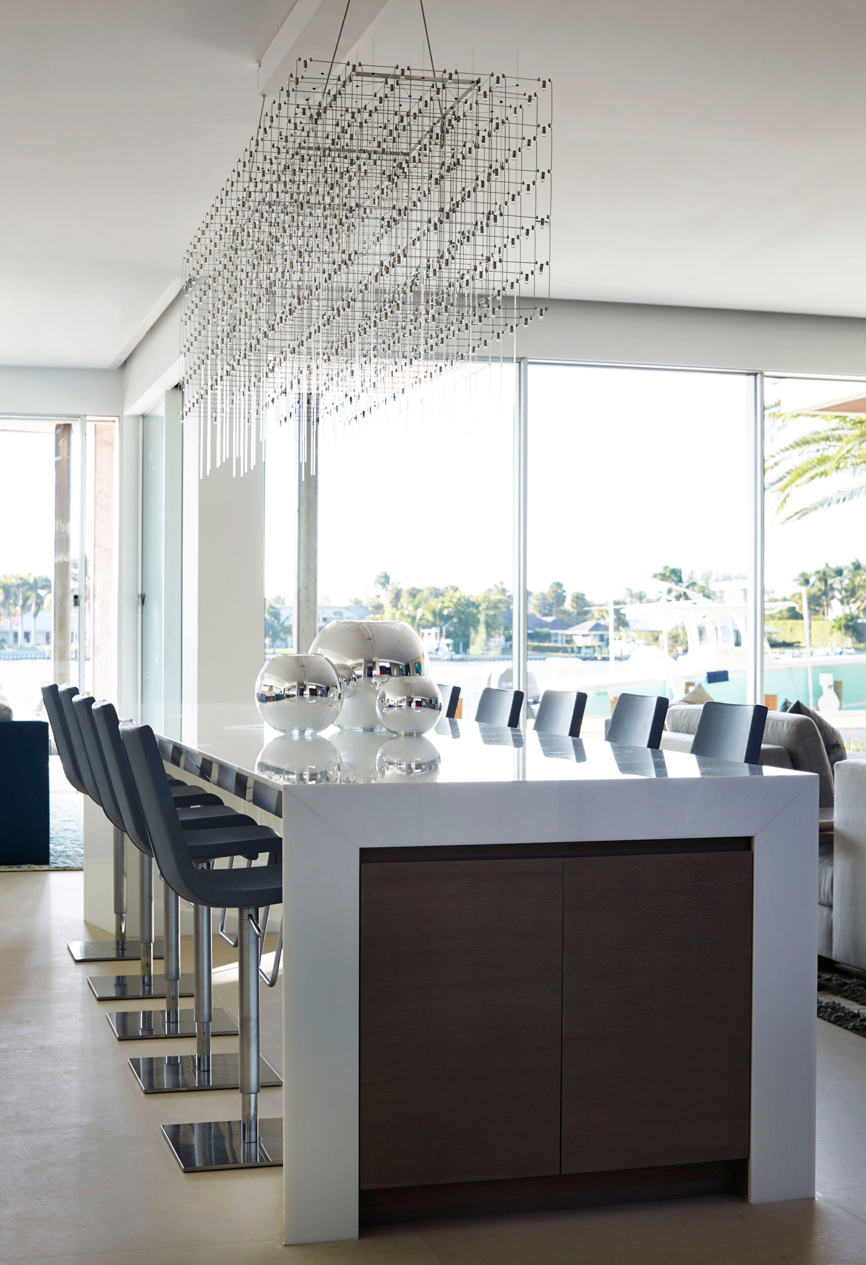 Lost Tree Way - Dining area of modern Palm Beach, FL home with glossy white table, geometric chandelier,...