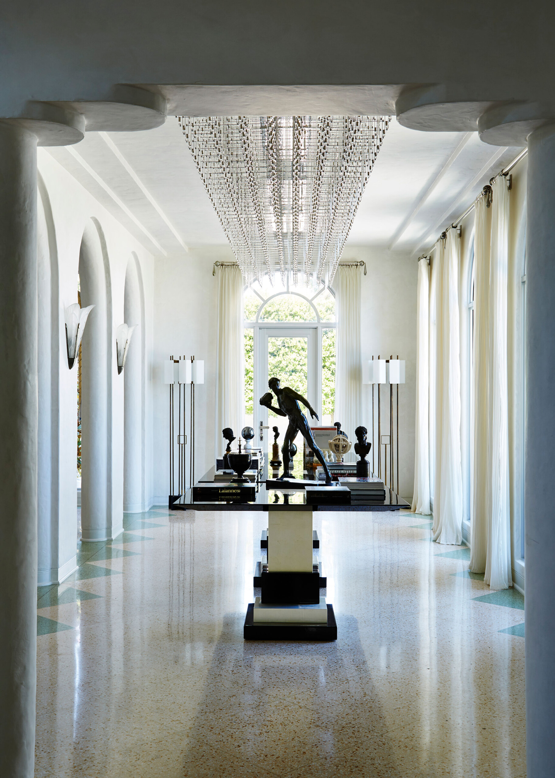 Historic West Palm Beach - Luxury hallway with arched doorways, floor to ceiling windows, and statement...