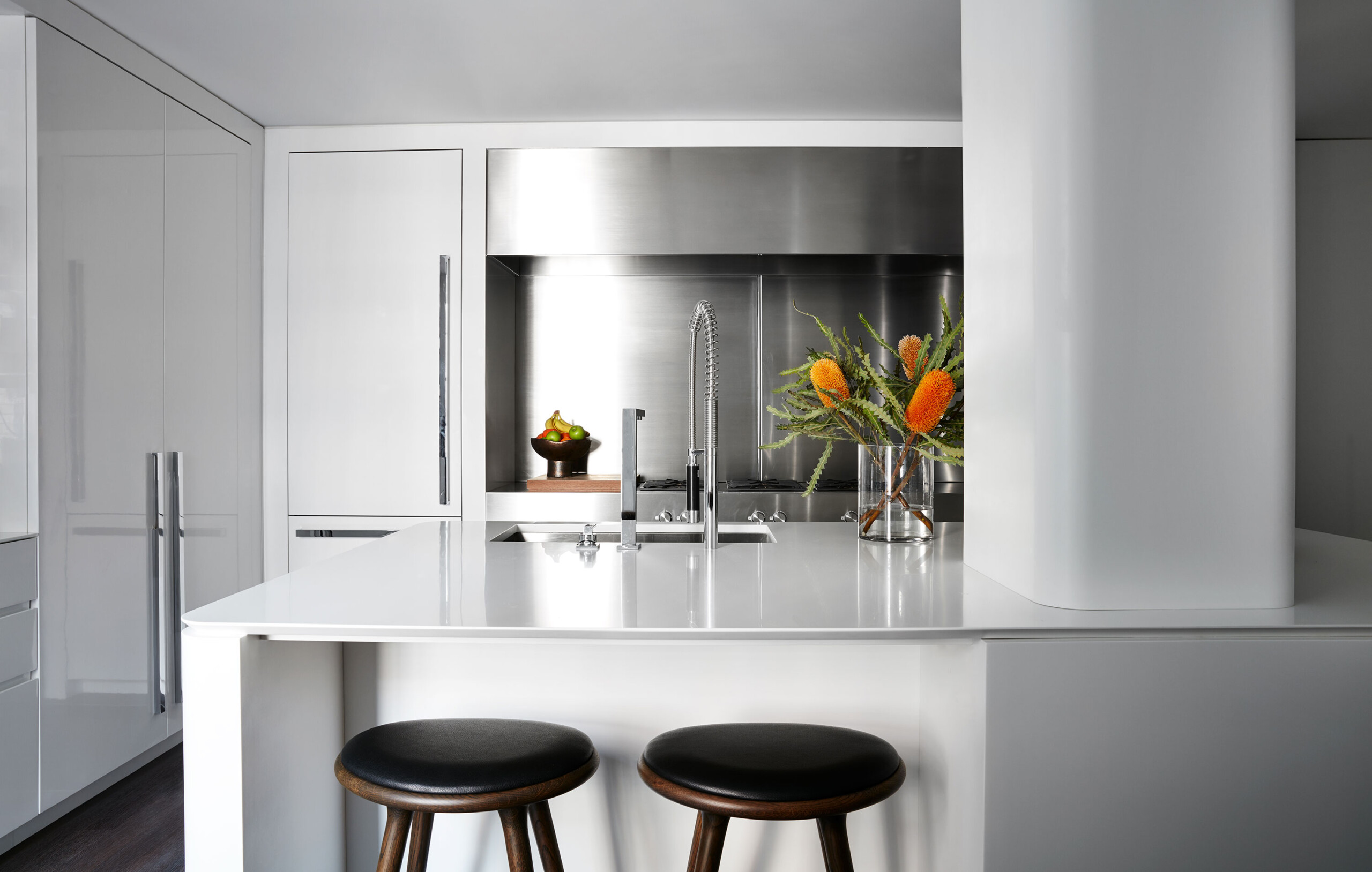 Park Avenue - White Corian kitchen with modern stainless steel backsplash and hood, dark stained...