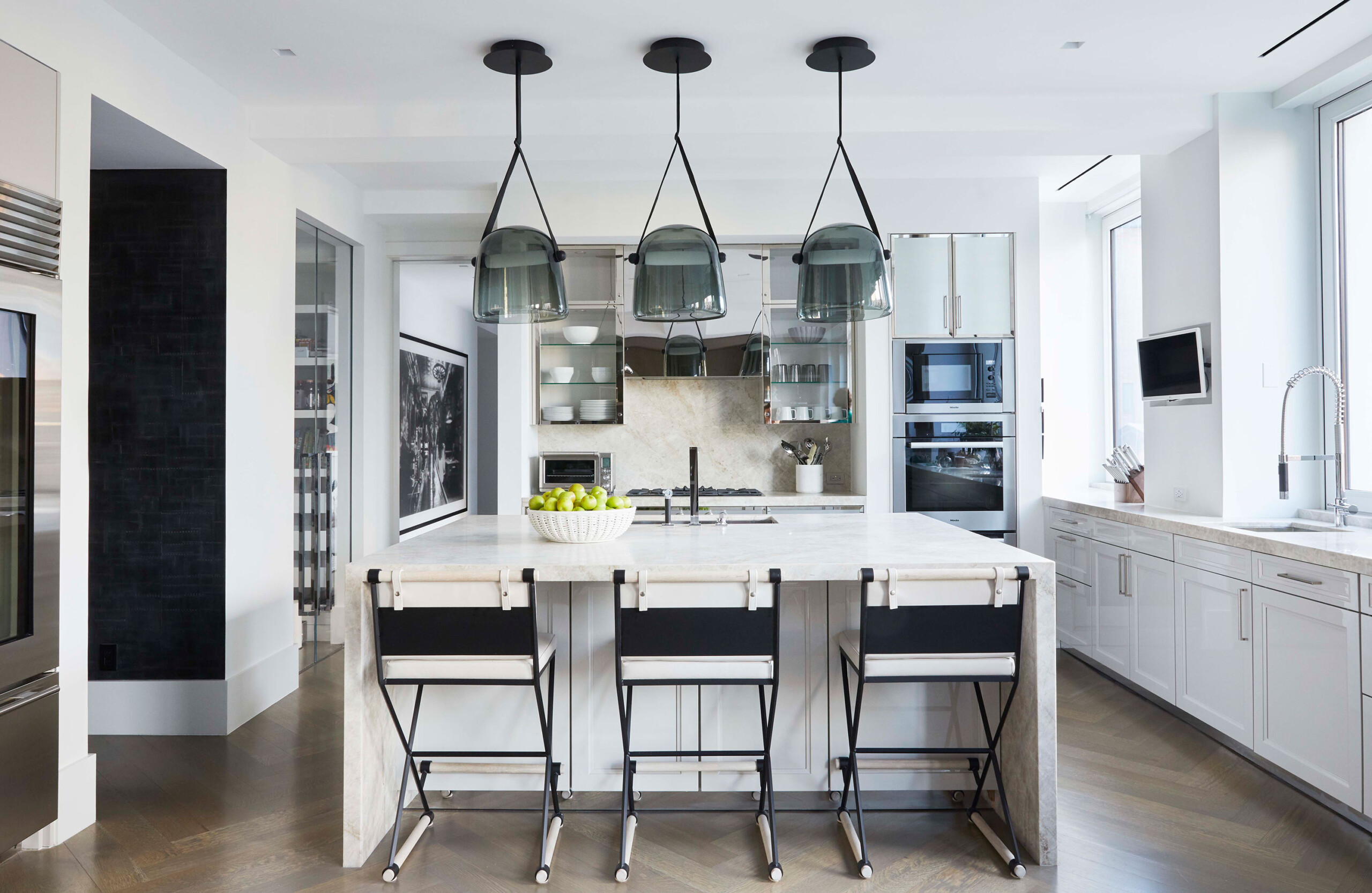 Leonard Street - Contemporary white kitchen with grey glass pendant lighting in Tribeca NY home....