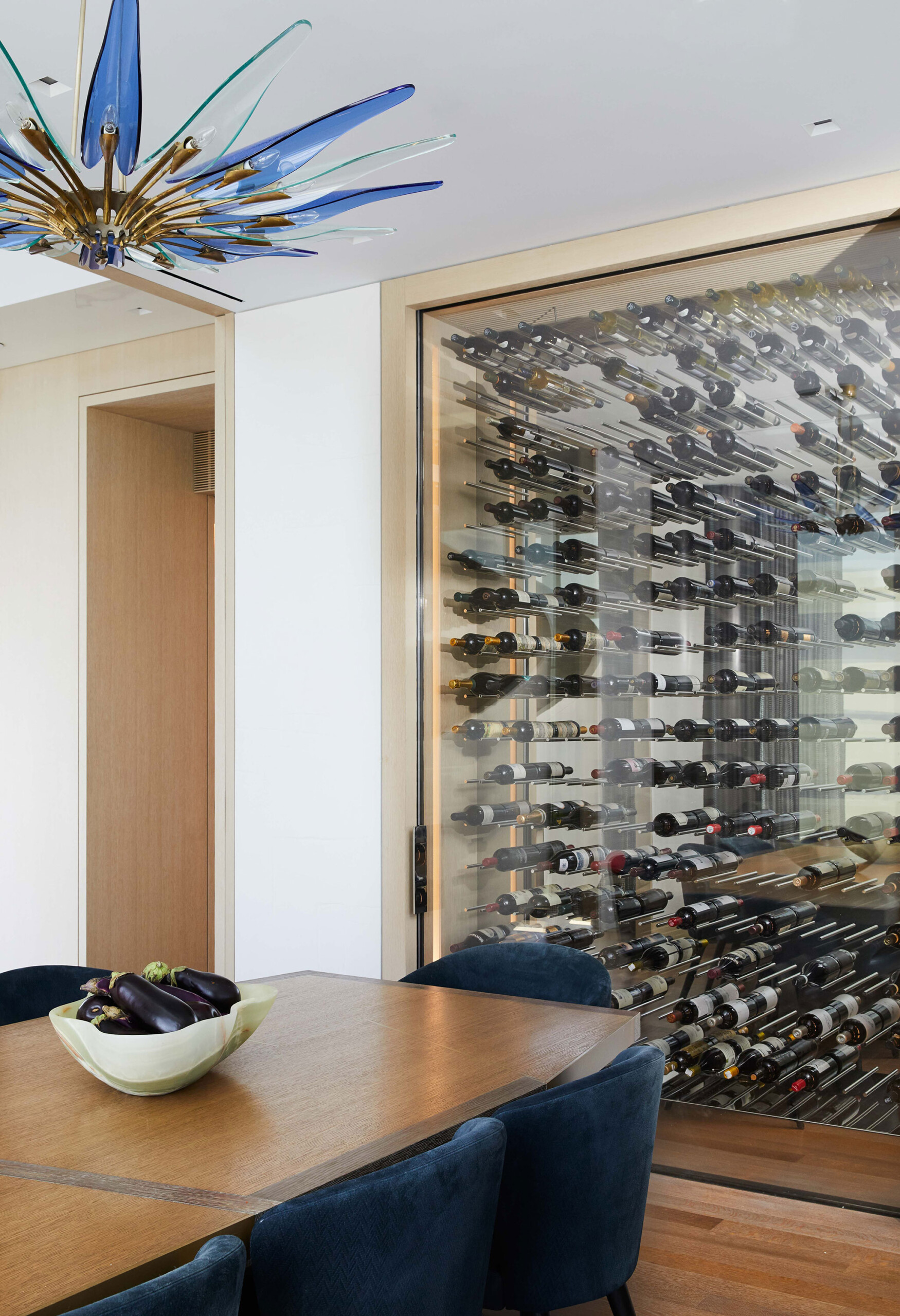 West Village Penthouse - Pembrooke & Ives Dining room with navy upholstered chairs, medium wood...