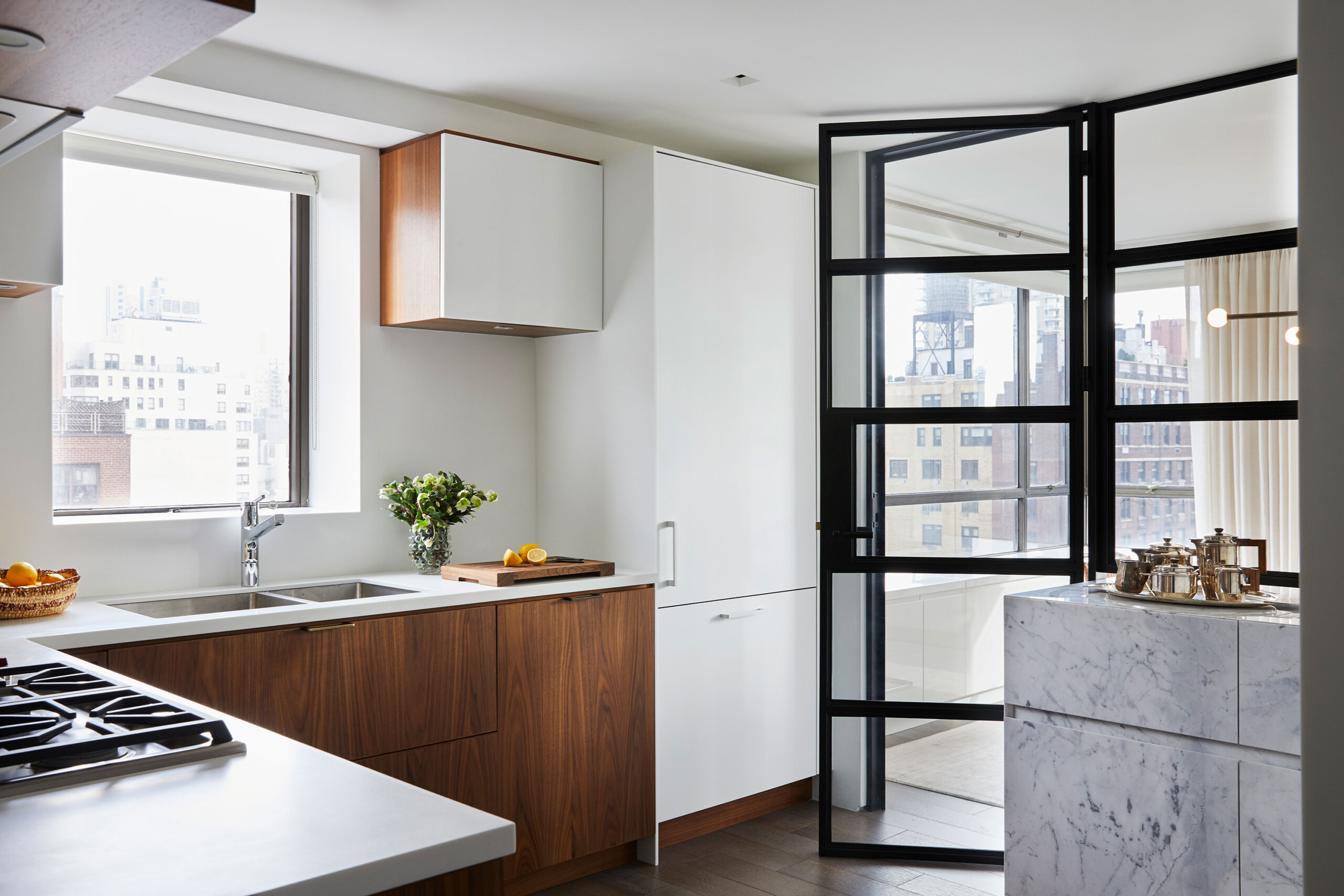 Uptown Pied-á-Terre - Mid-century modern kitchen with white and walnut counters & cabinets, and...