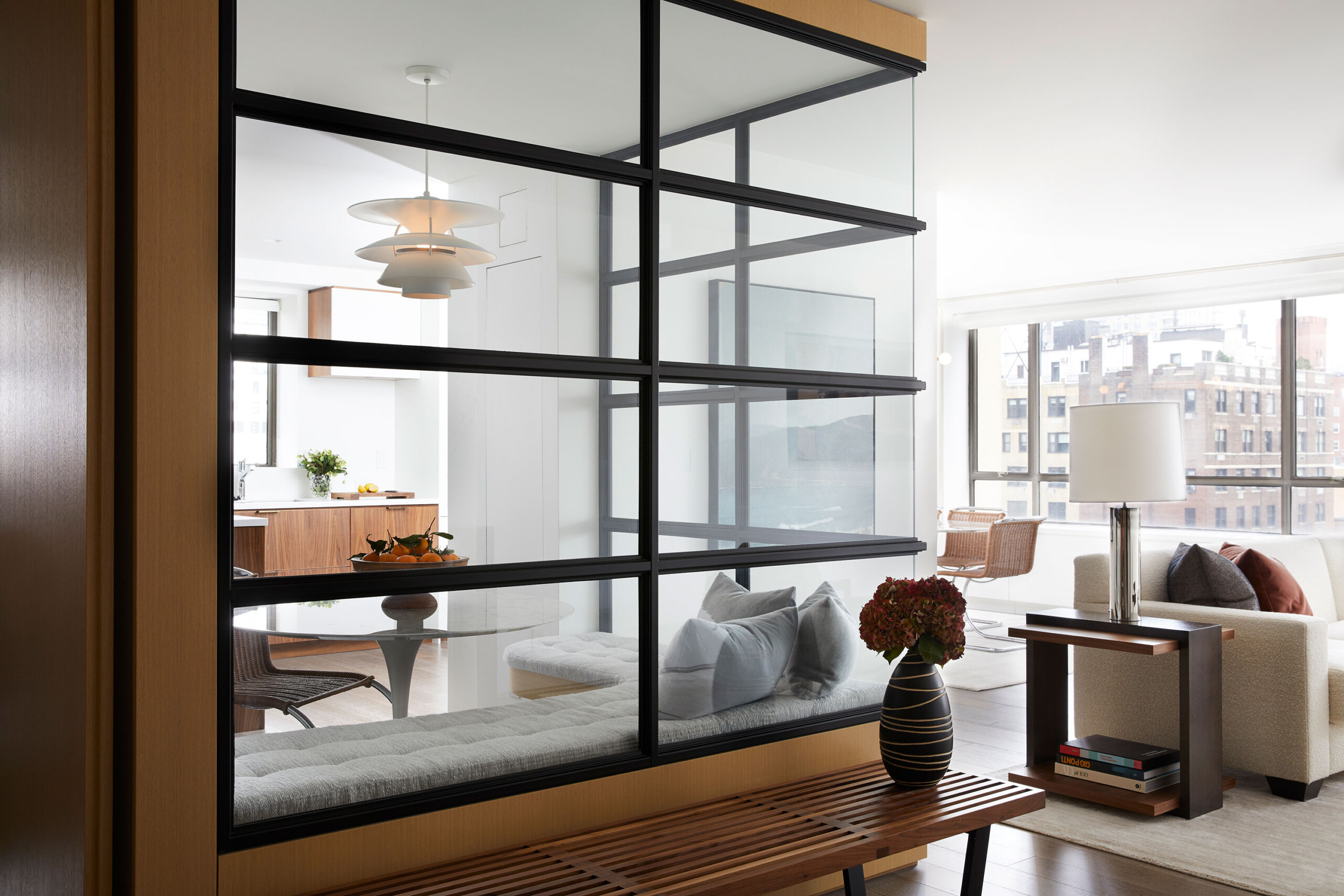 Uptown Pied-á-Terre - Details of an eat-in kitchen seen through a glass dividing wall from a mid-century...