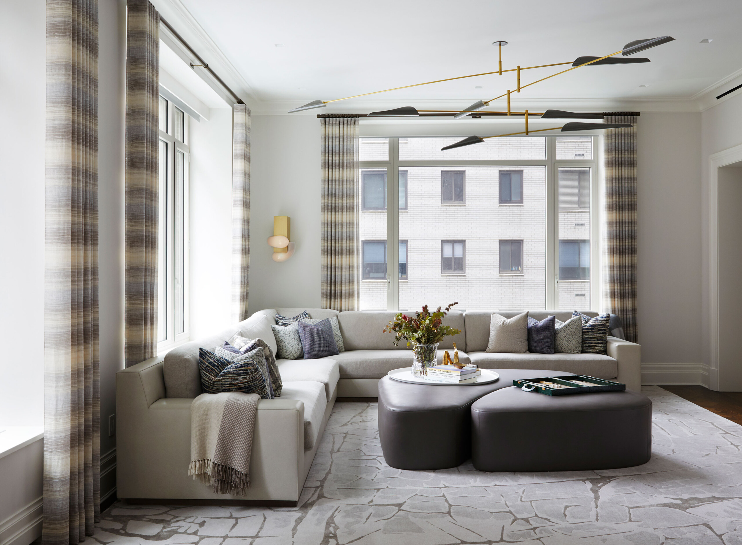 East End Avenue - Neutral-toned living room with L-shaped sofa and leather coffee table under David...