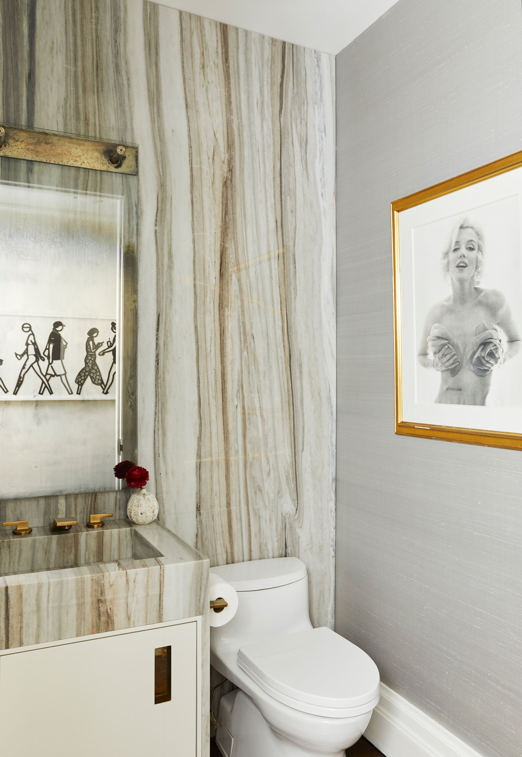 East End Avenue - Modern bathroom featuring veined stone accent wall and vanity with brass hardware....