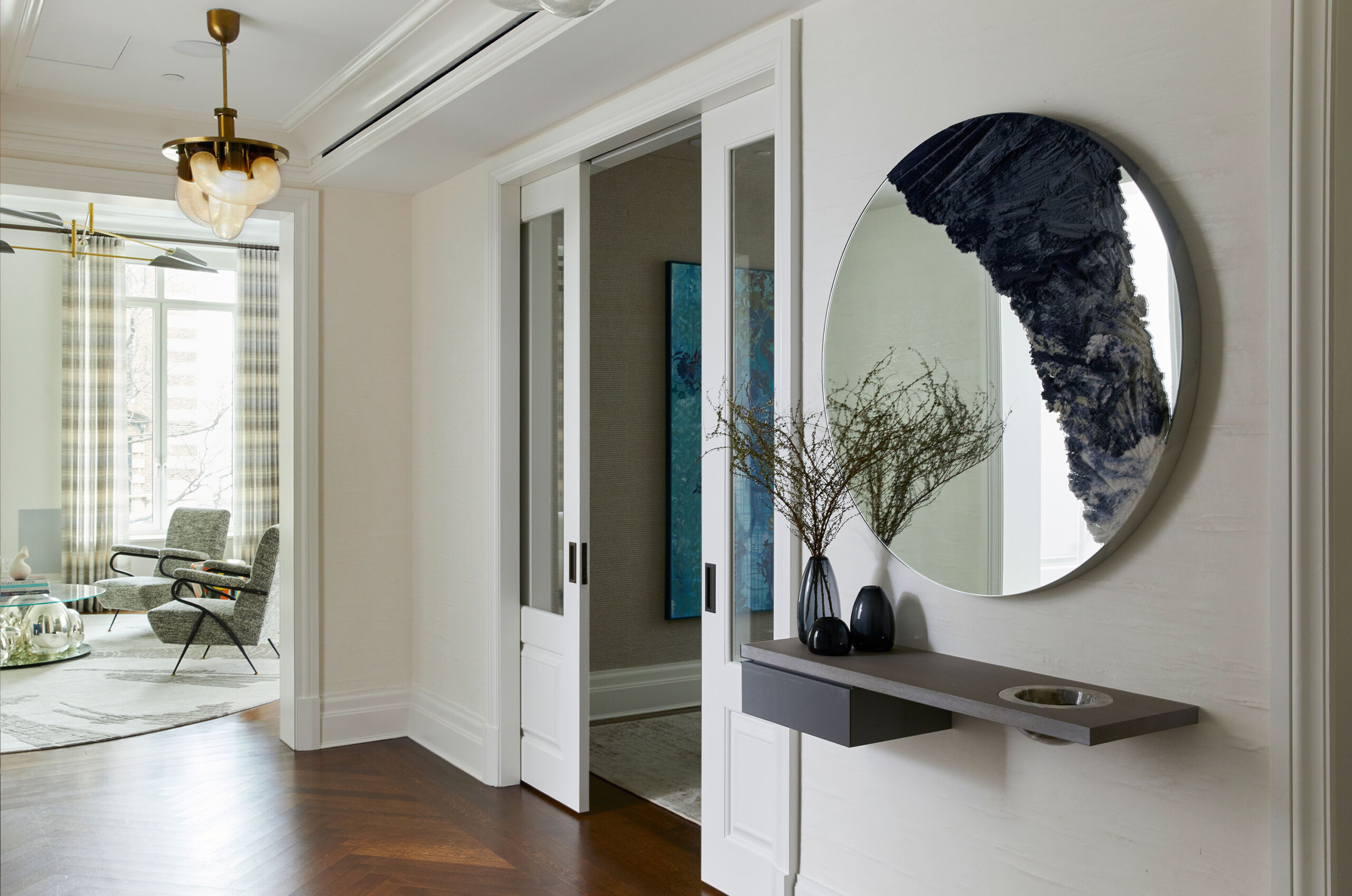 East End Avenue - Entryway of New York apartment featuring large circular entry mirror and floating...