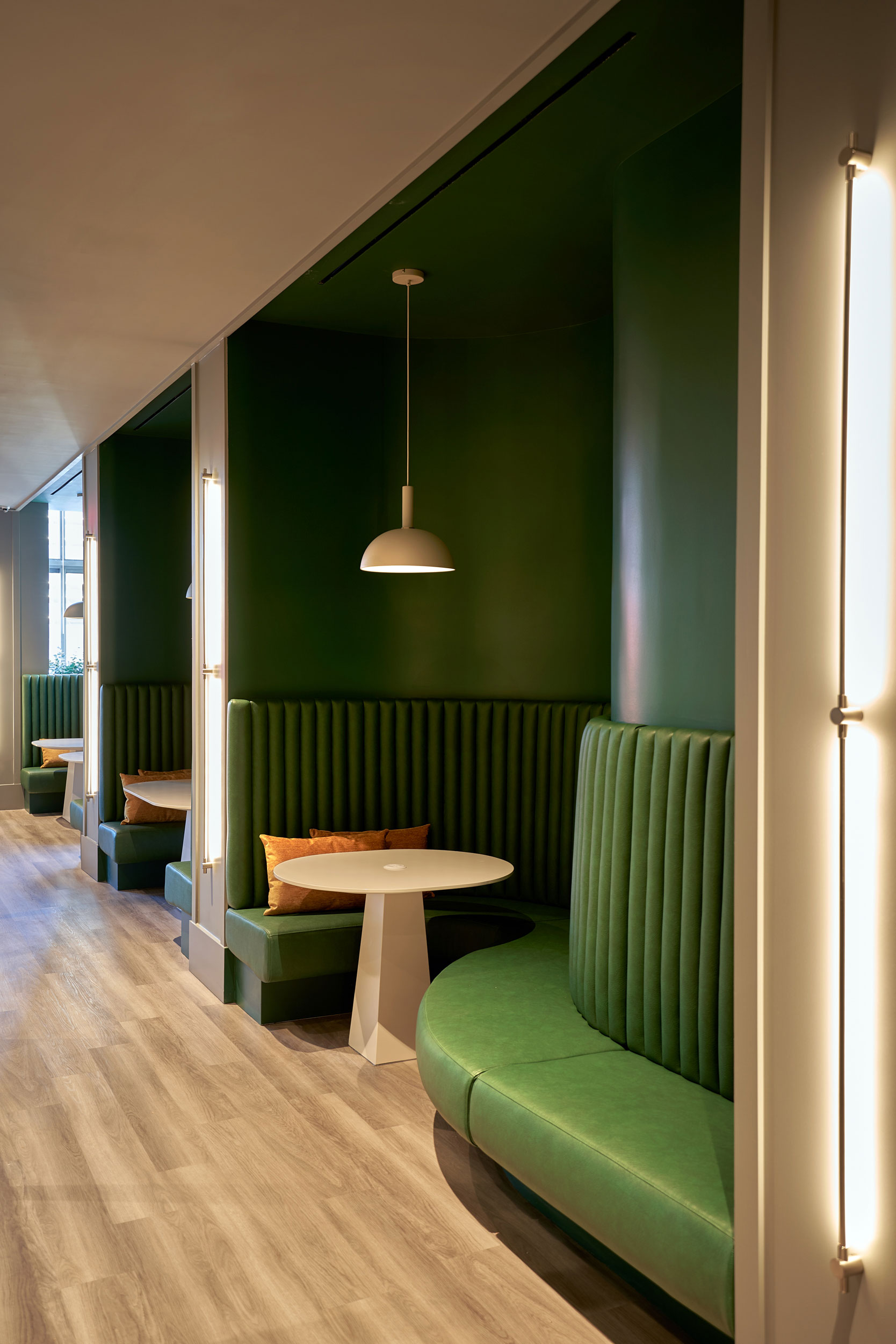 The Biltmore - Small dining tables and green lounge seating. Interior design by Pembrooke & Ives....