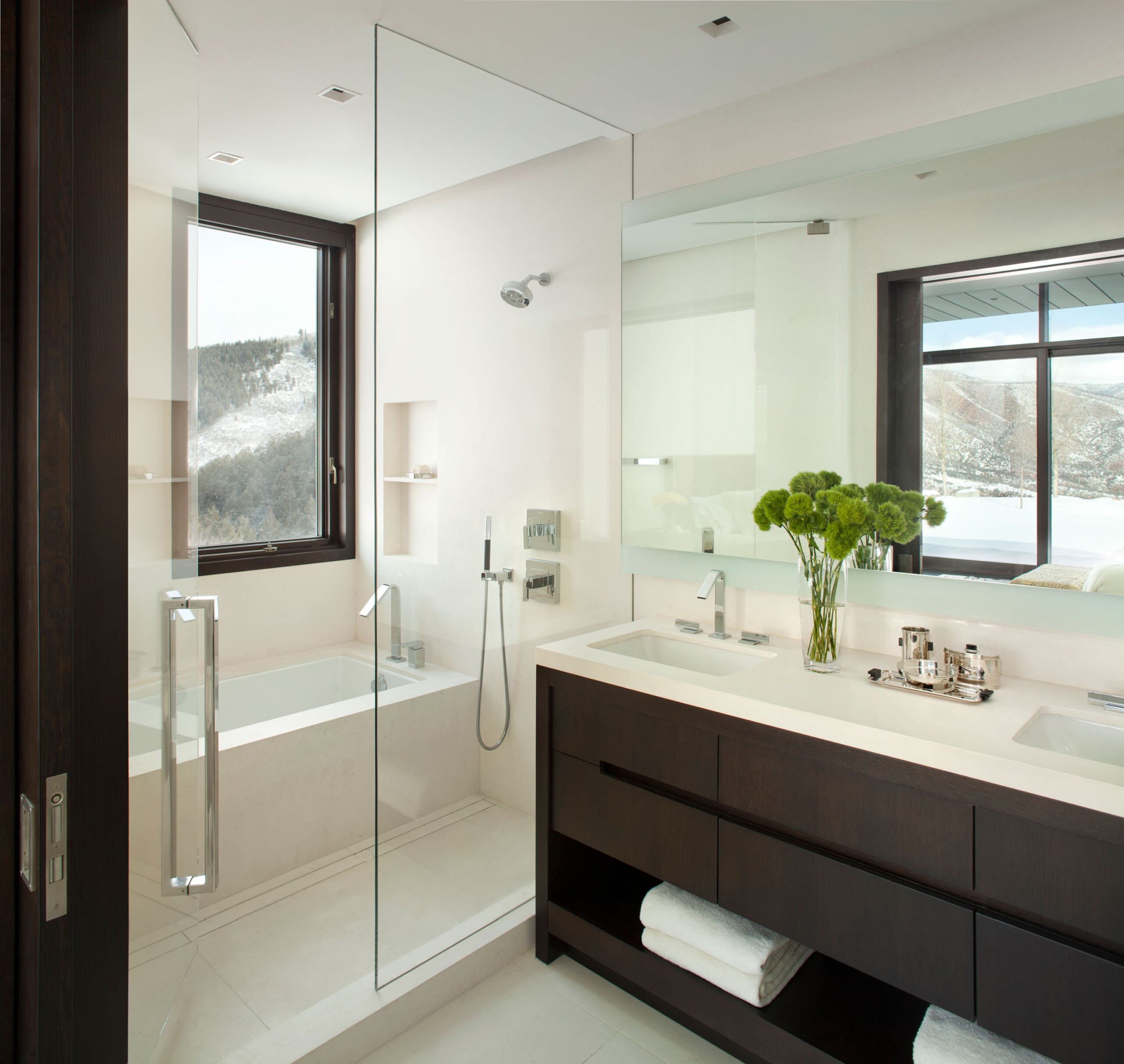 Modern Mountain - Modern bathrpp, with white squared tub, glass door, and dark wood vanity with...