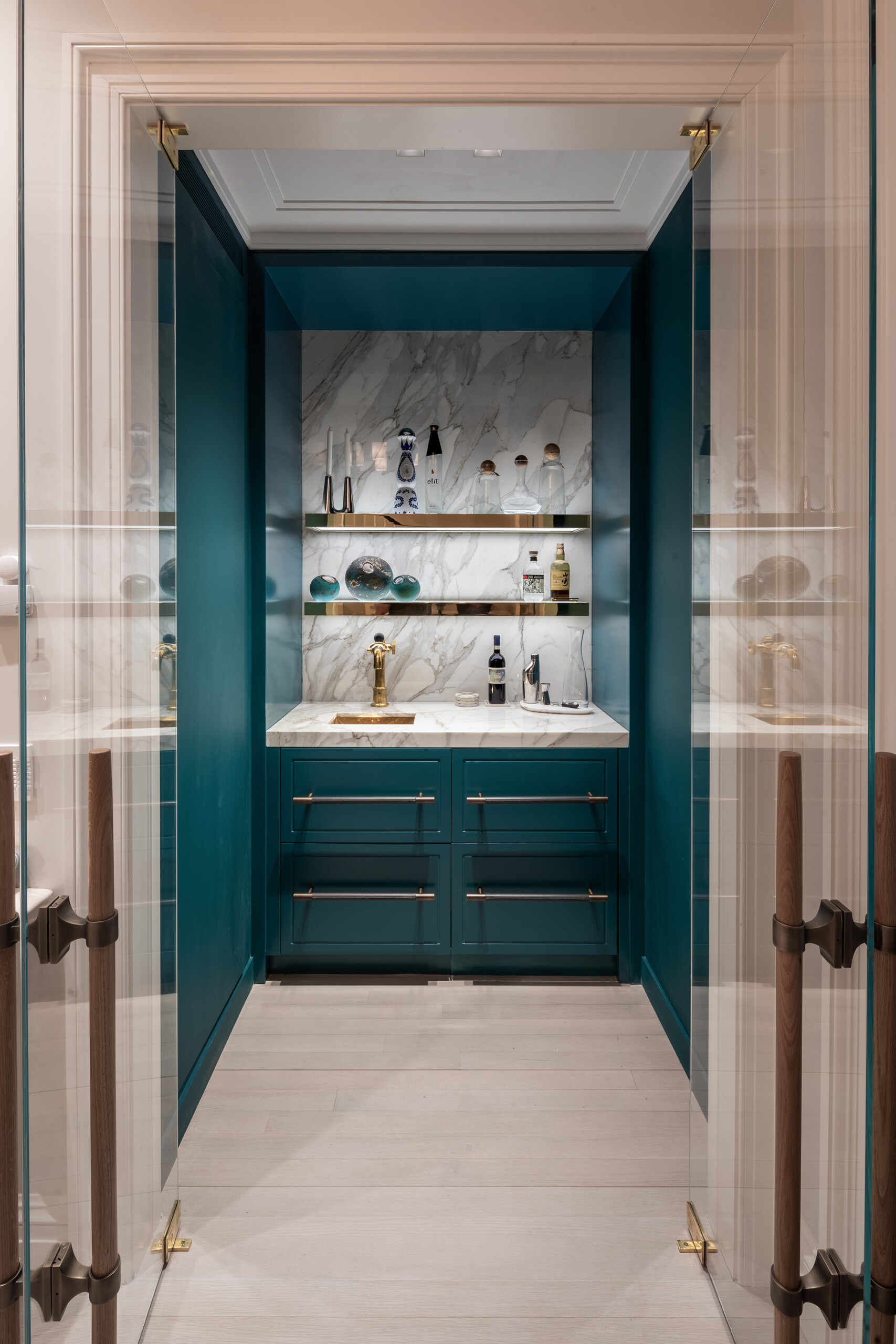 Townhouse - Teal bar in New York townhouse with chrome illuminated shelving and white marble backsplash....