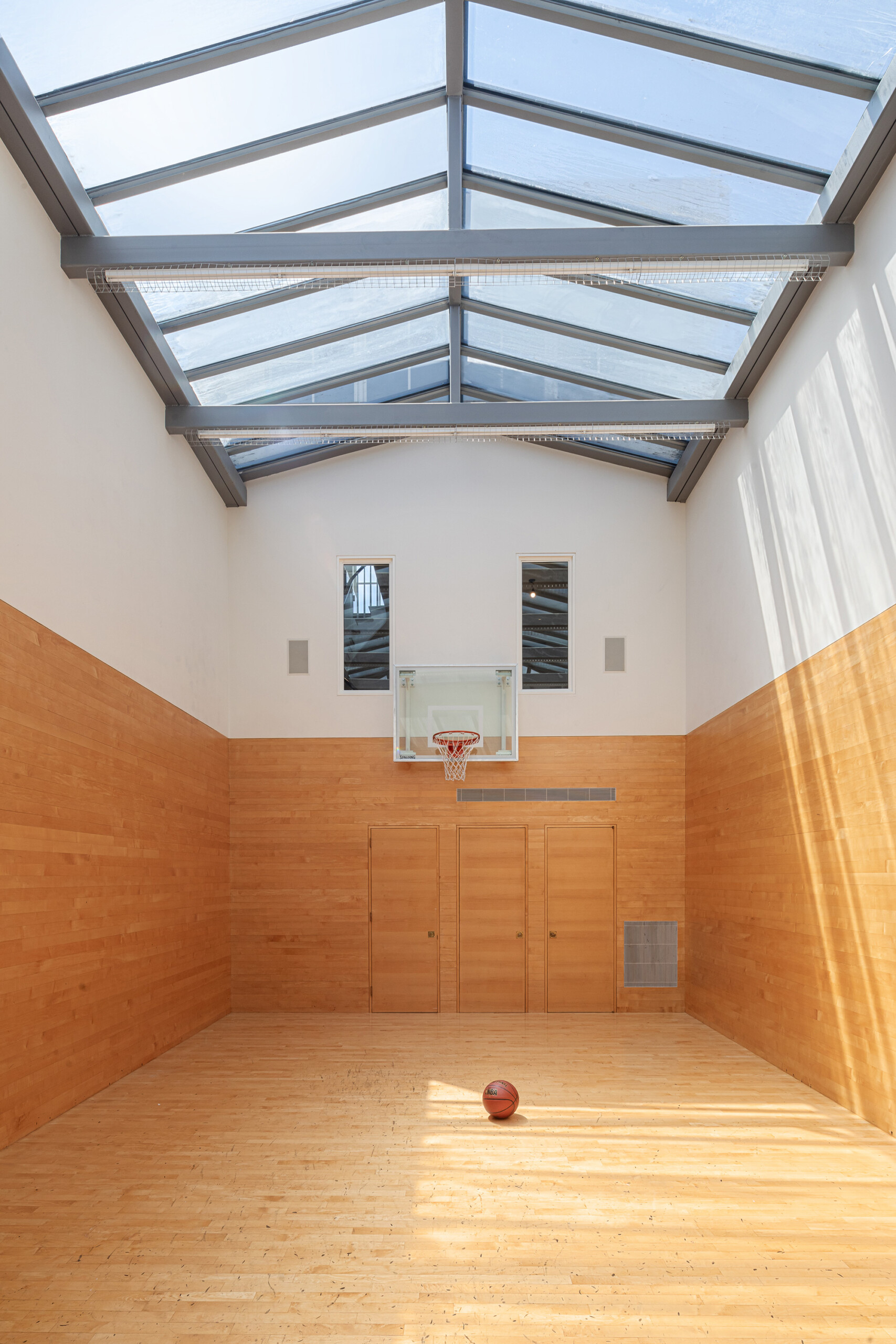 Townhouse - Basketball court in New York townhouse featuring galss pitched ceiling and light wood...