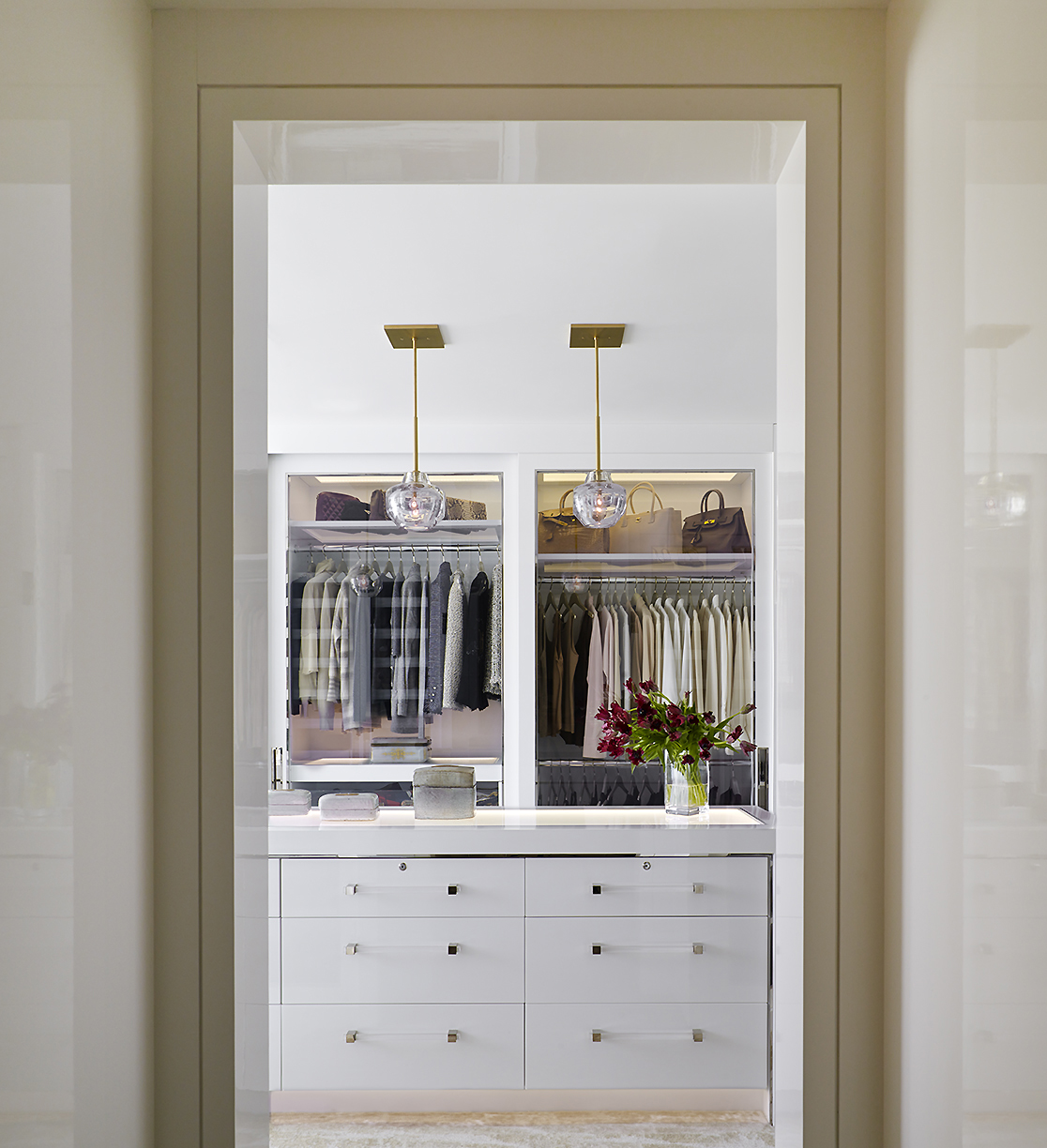 Classical Park Avenue - Luxury walk-in closet with illuminated shelving and glass pendant lighting...