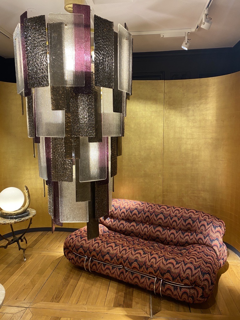 Modern with a touch of art deco. Gold walls with popping patterned loveseat.