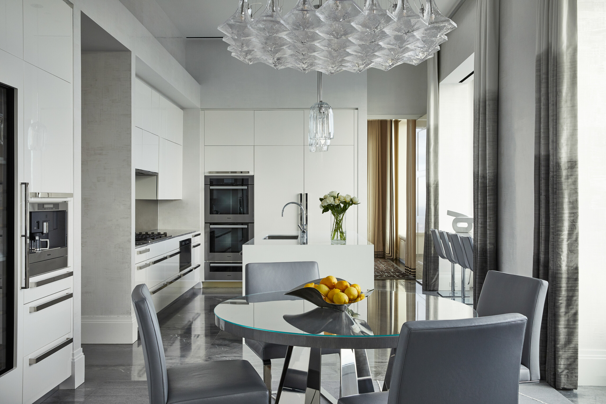 Kitchen from Pembrooke & Ives project: Penthouse in the Sky. Modern white kitchen with chrome hardware...