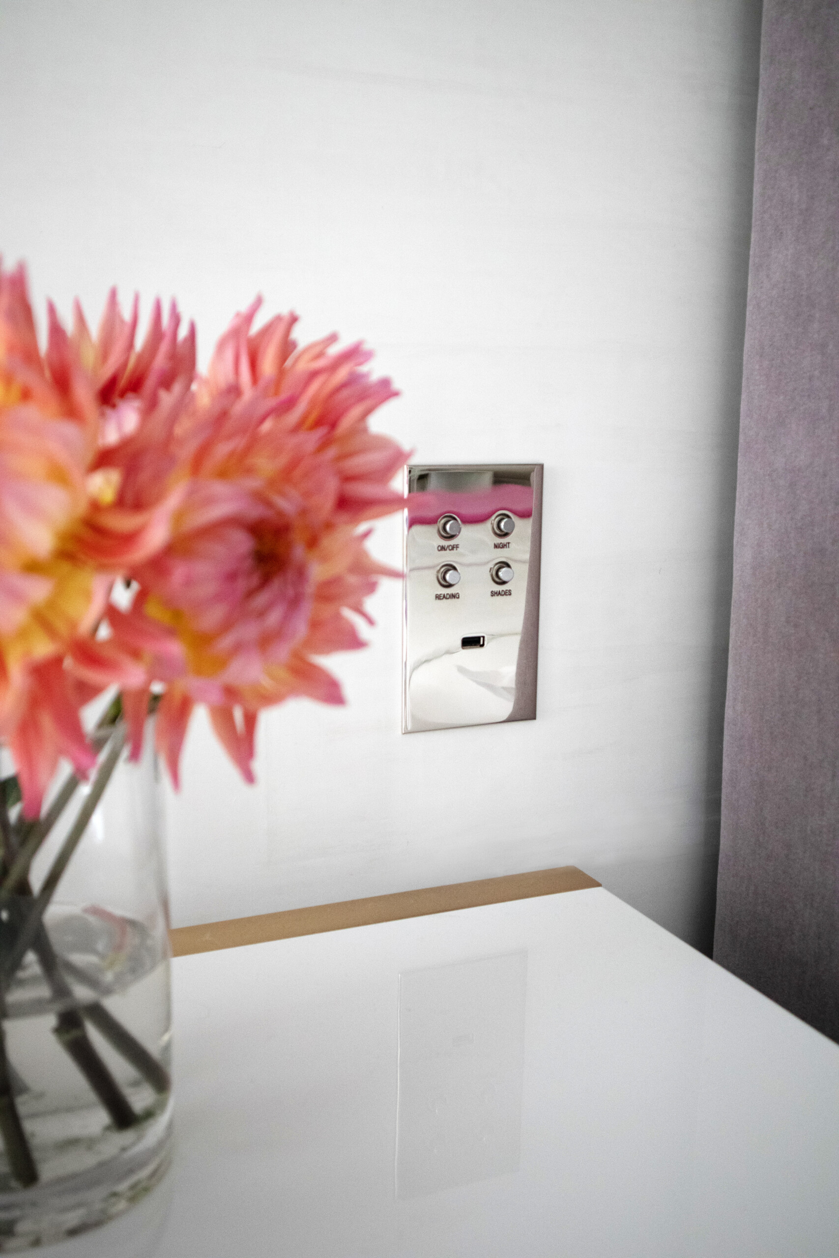Silver modern sleek light switch with circle buttons featured by Pembrooke & Ives