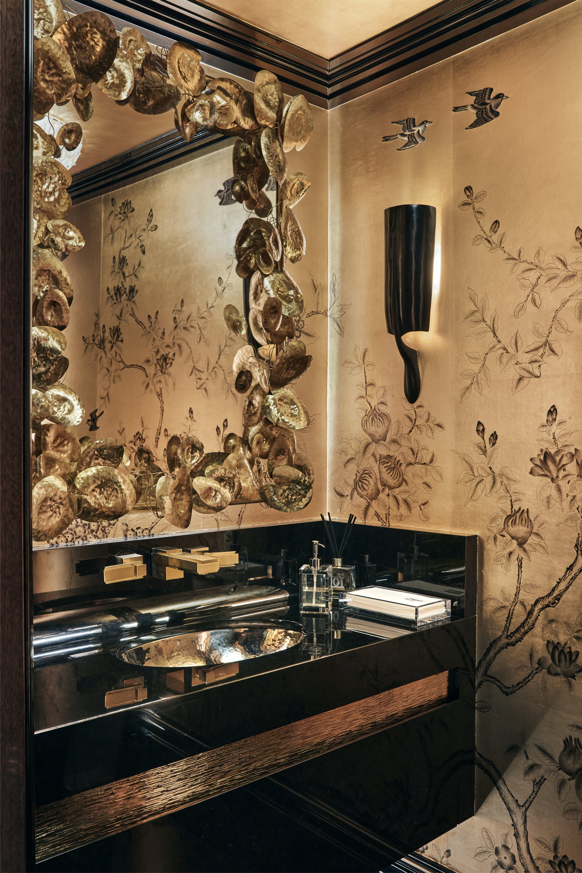New York City interior design by Pembrooke & Ives. Ornate powder room with gold wallpaper, black...
