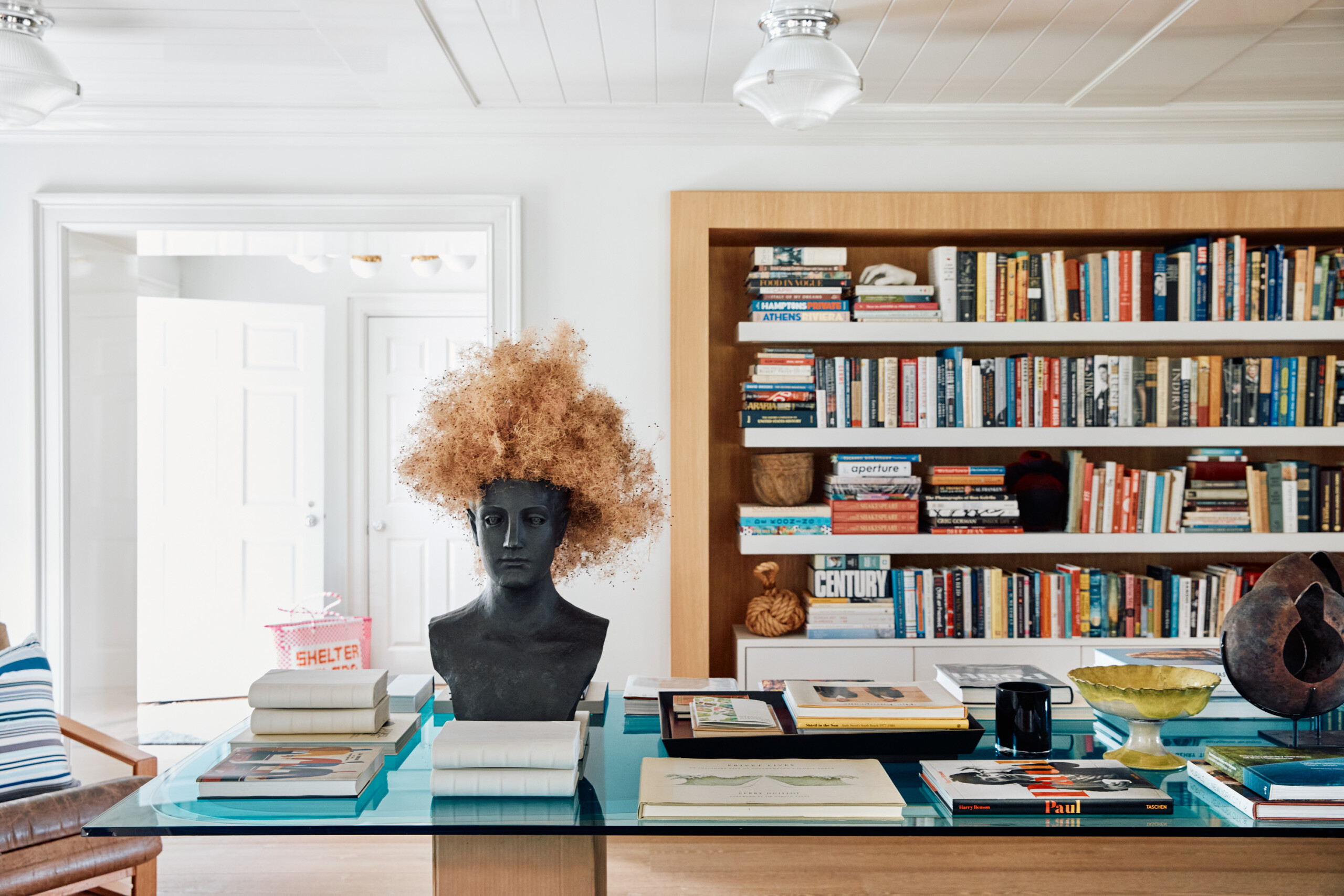 Hamptons Interior Design by Pembrooke & Ives. Library with eclectic furnishings and art objects.
