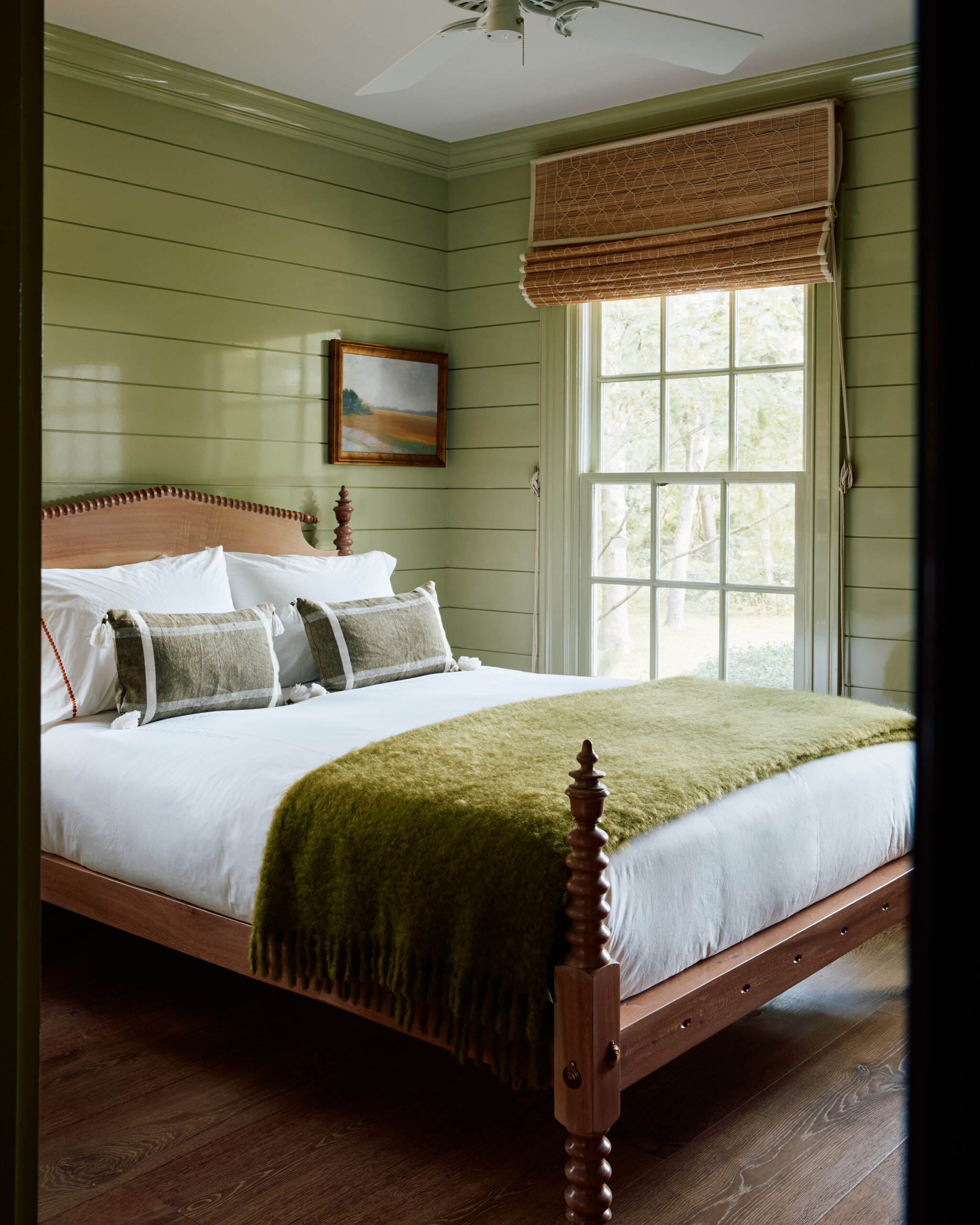 Hamptons Interior Design by Pembrooke & Ives. Bedroom with green wood paneling and wall art.