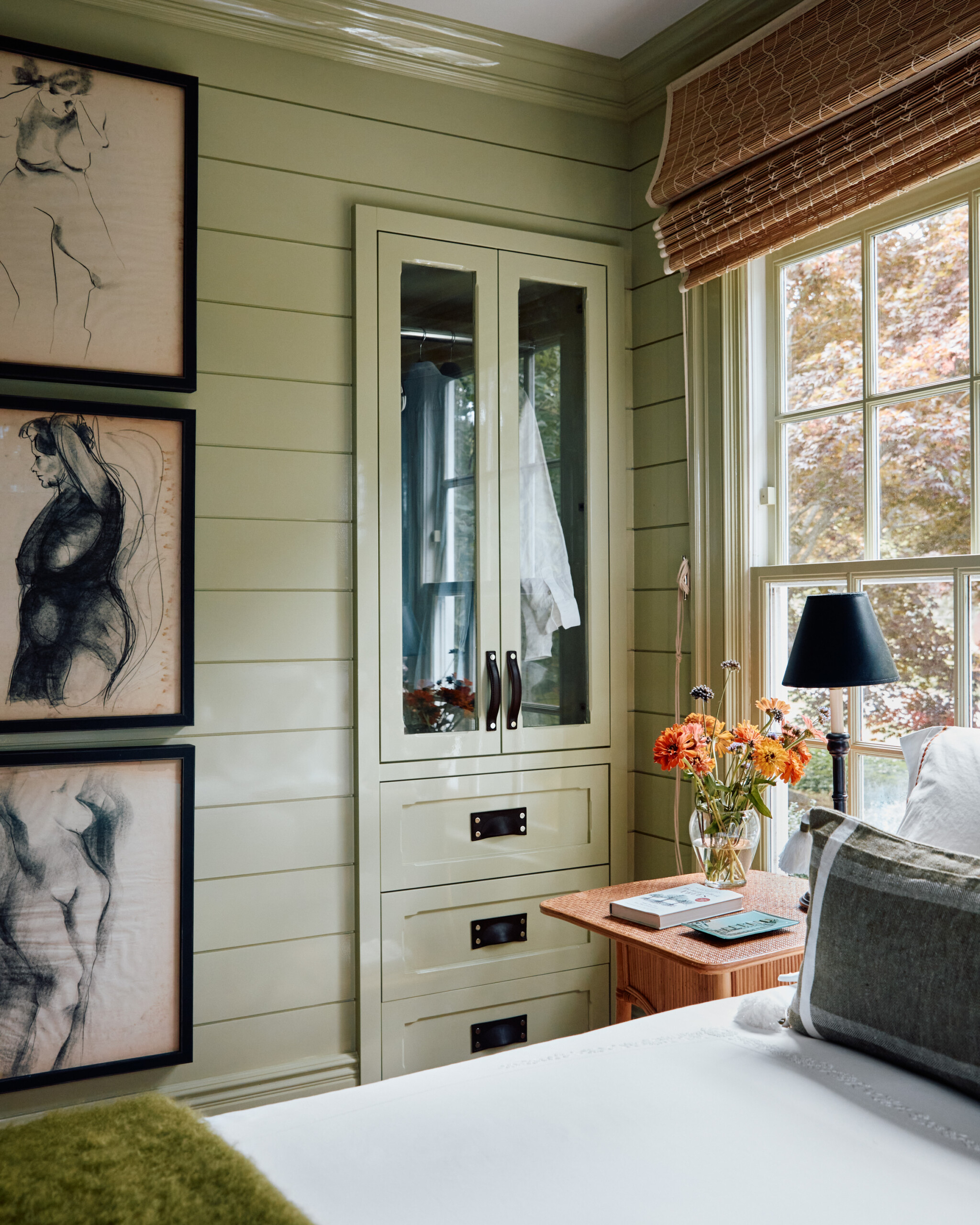 Hamptons Interior Design by Pembrooke & Ives. Bedroom with green wood paneling and built-in storage.