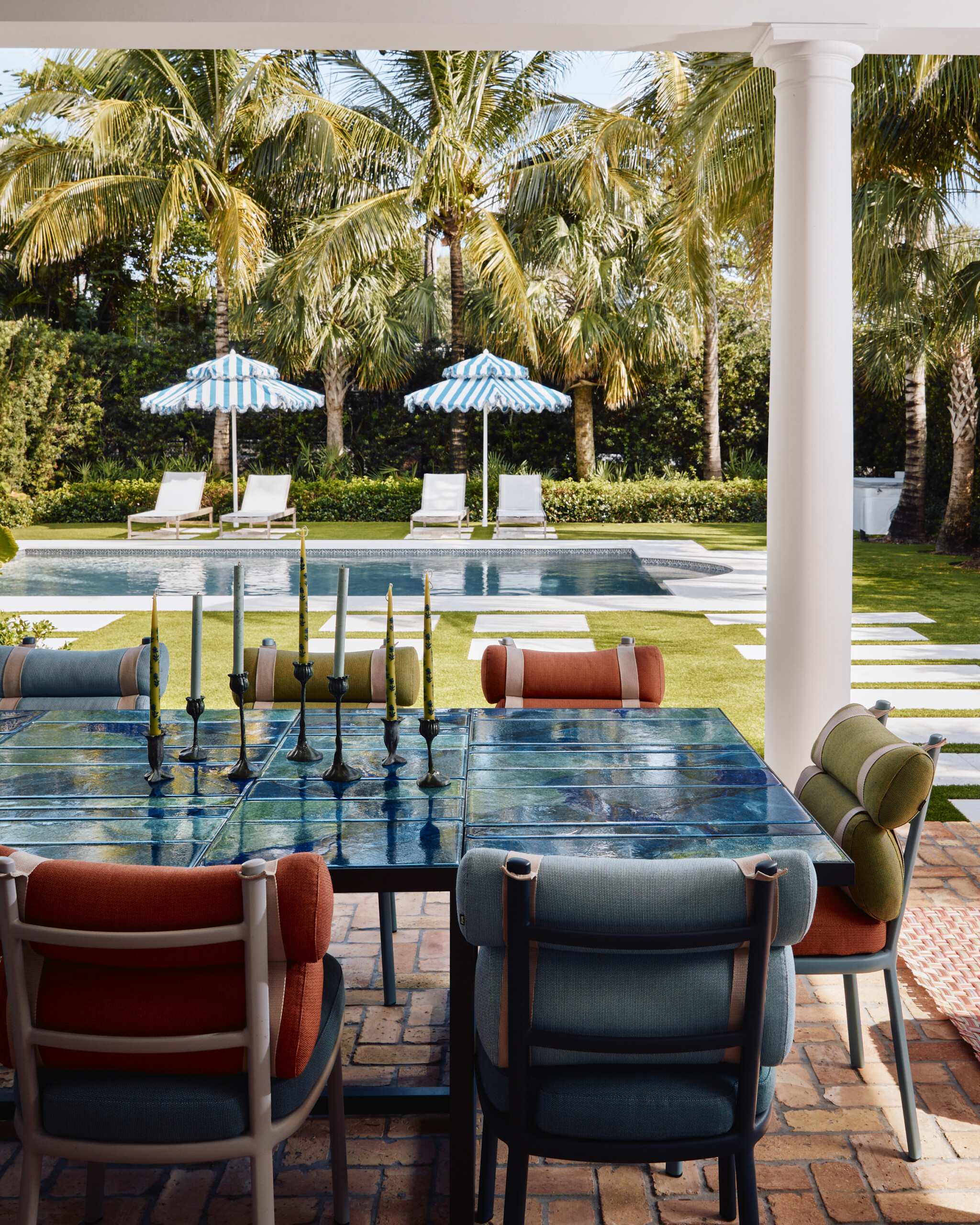 Palm Beach Interior Design by Pembrooke & Ives. Outdoor dining table with tile top by the pool.