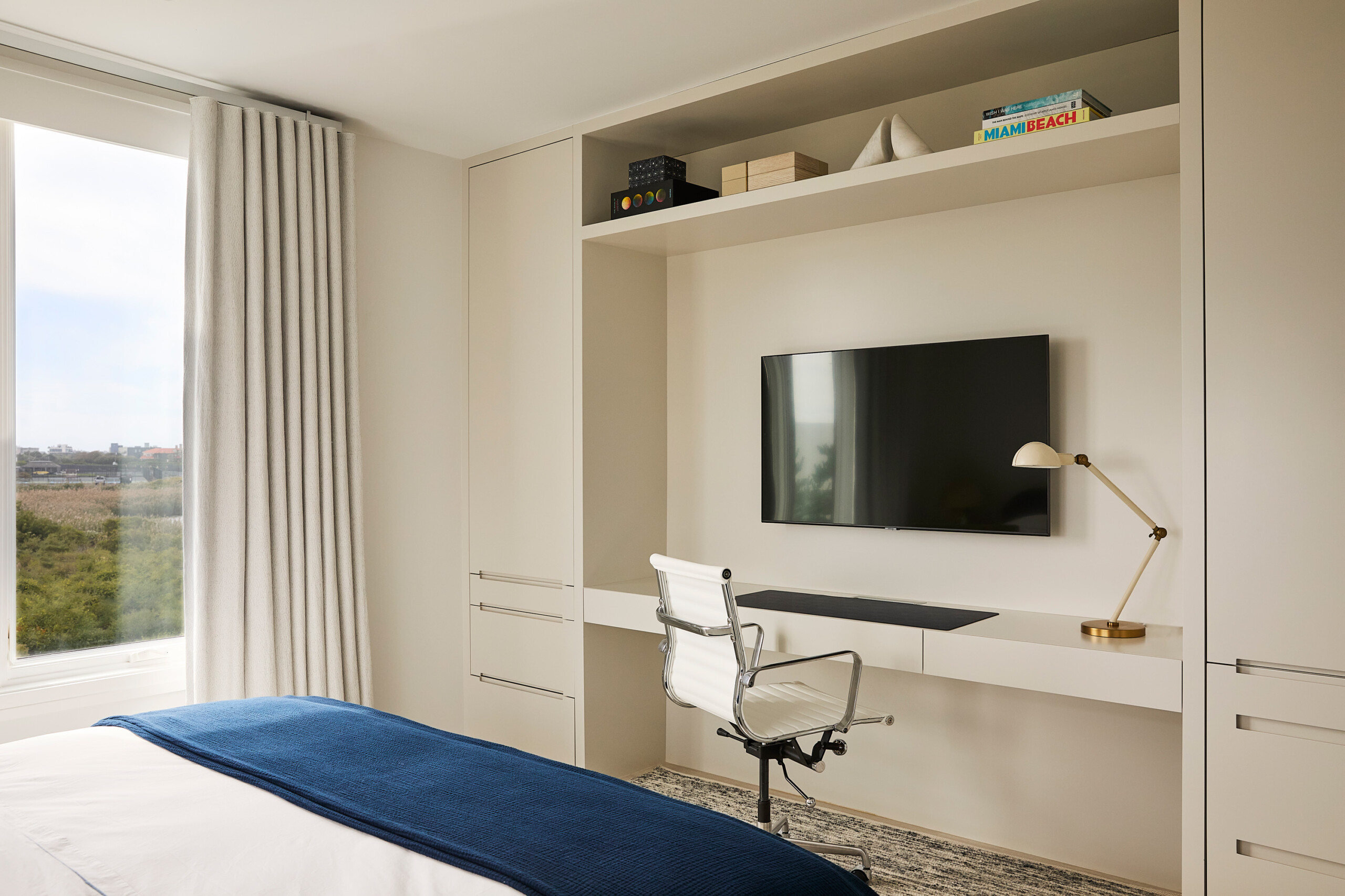 Hamptons Interior Design by Pembrooke & Ives. Bedroom with warm neutral palette and built-in desk.
