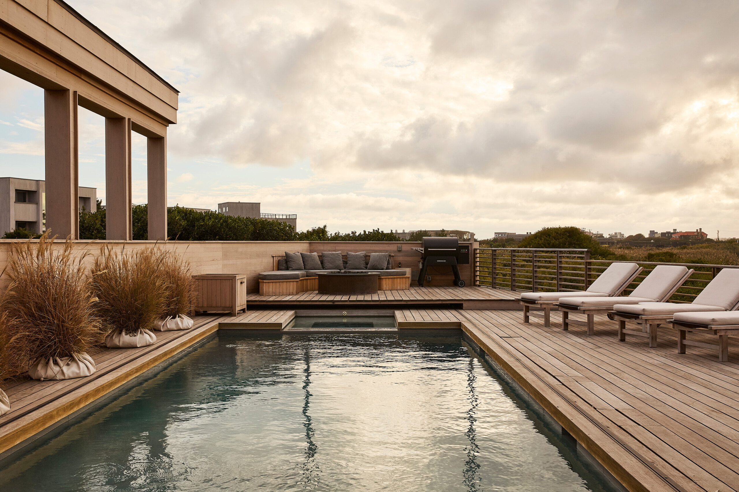 Hamptons Interior Design by Pembrooke & Ives. Exterior patio with lap pool, hot tub, and wooden...