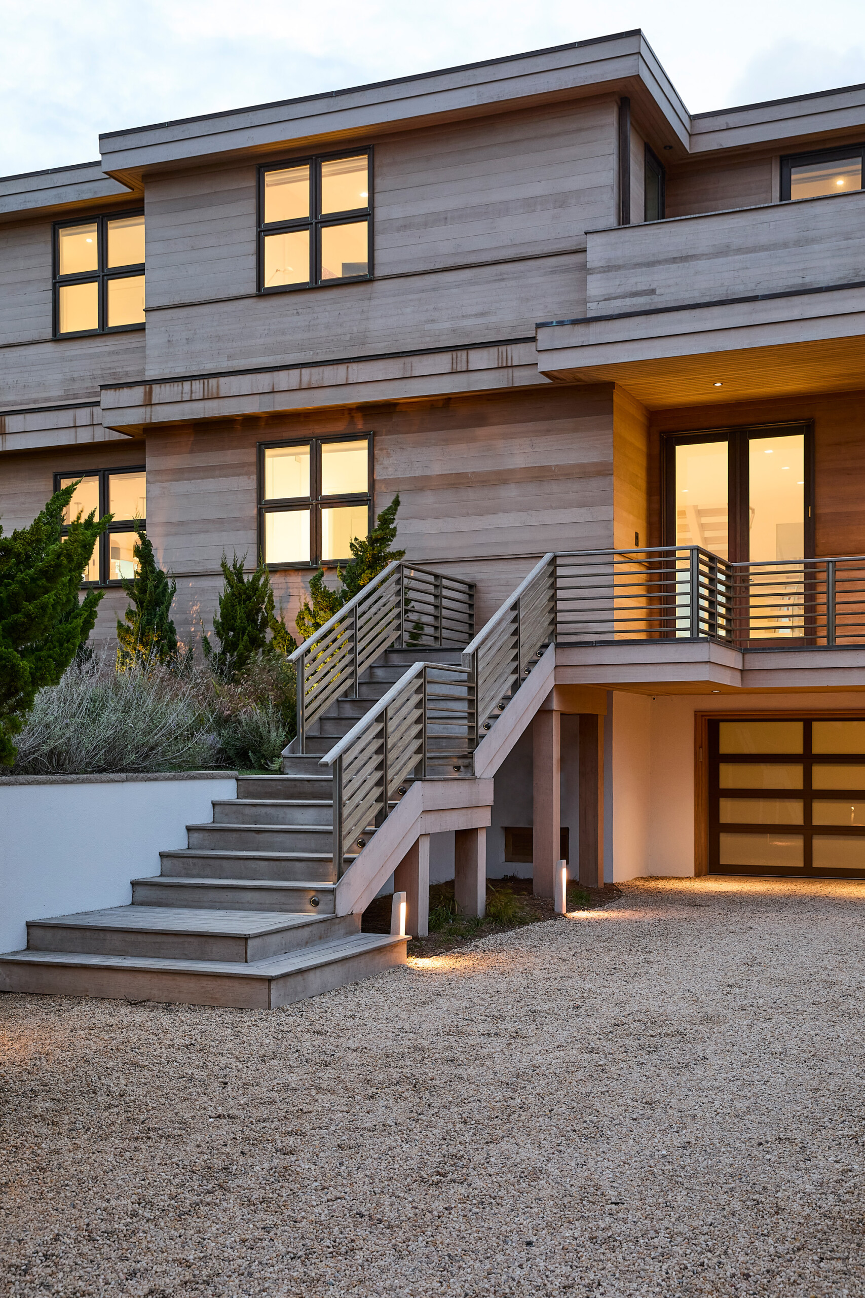 Hamptons Interior Design by Pembrooke & Ives. Front façade of Hamptons home with wood siding and...