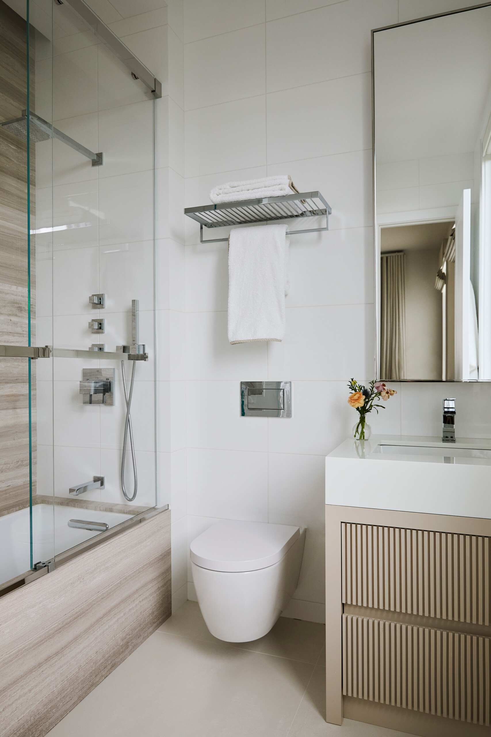 Hamptons Interior Design by Pembrooke & Ives. Neutral bathroom with stone accents on tub and shower...