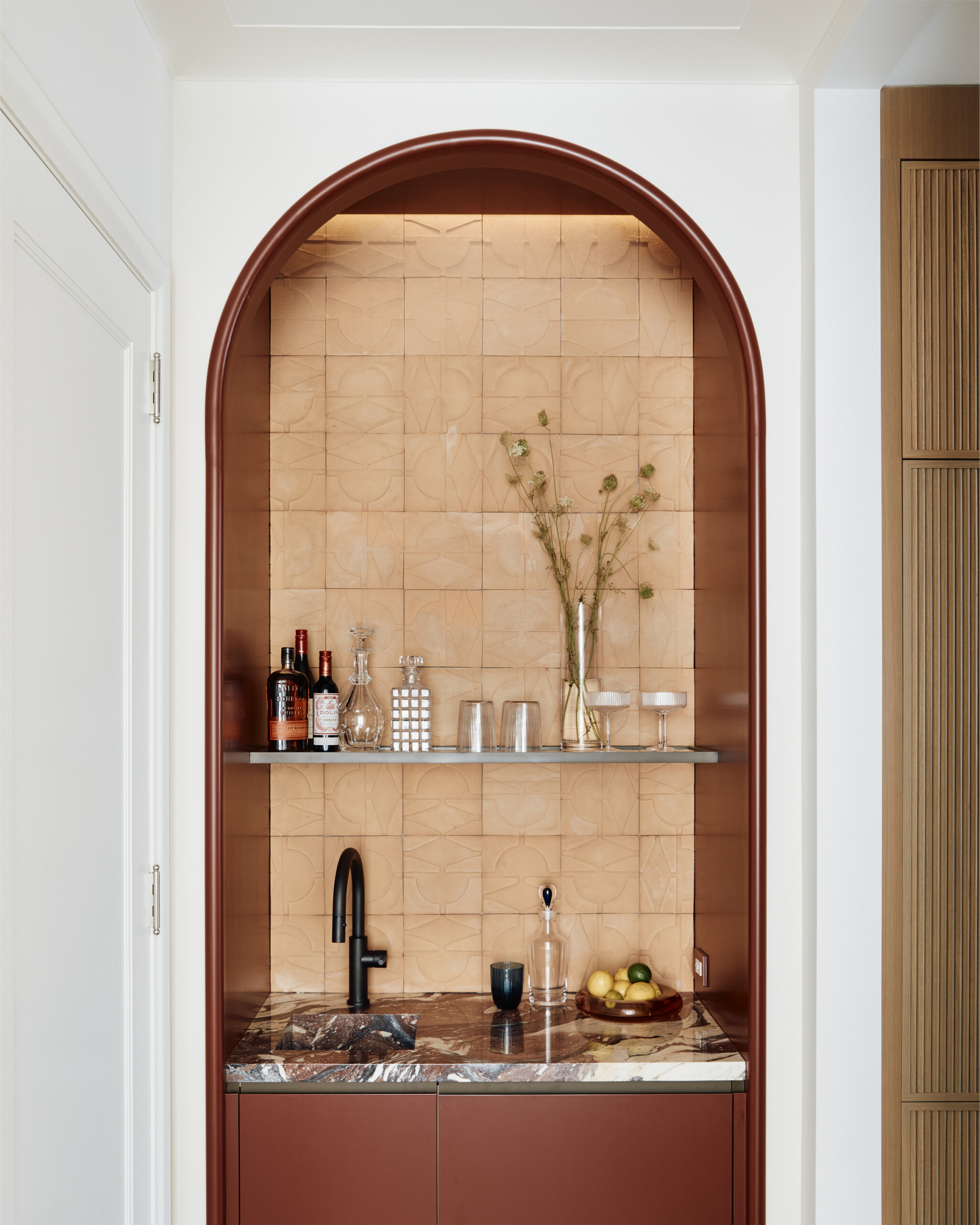 New York City interior design by Pembrooke & Ives. Wet bar with arch detail, handmade tiles, and...