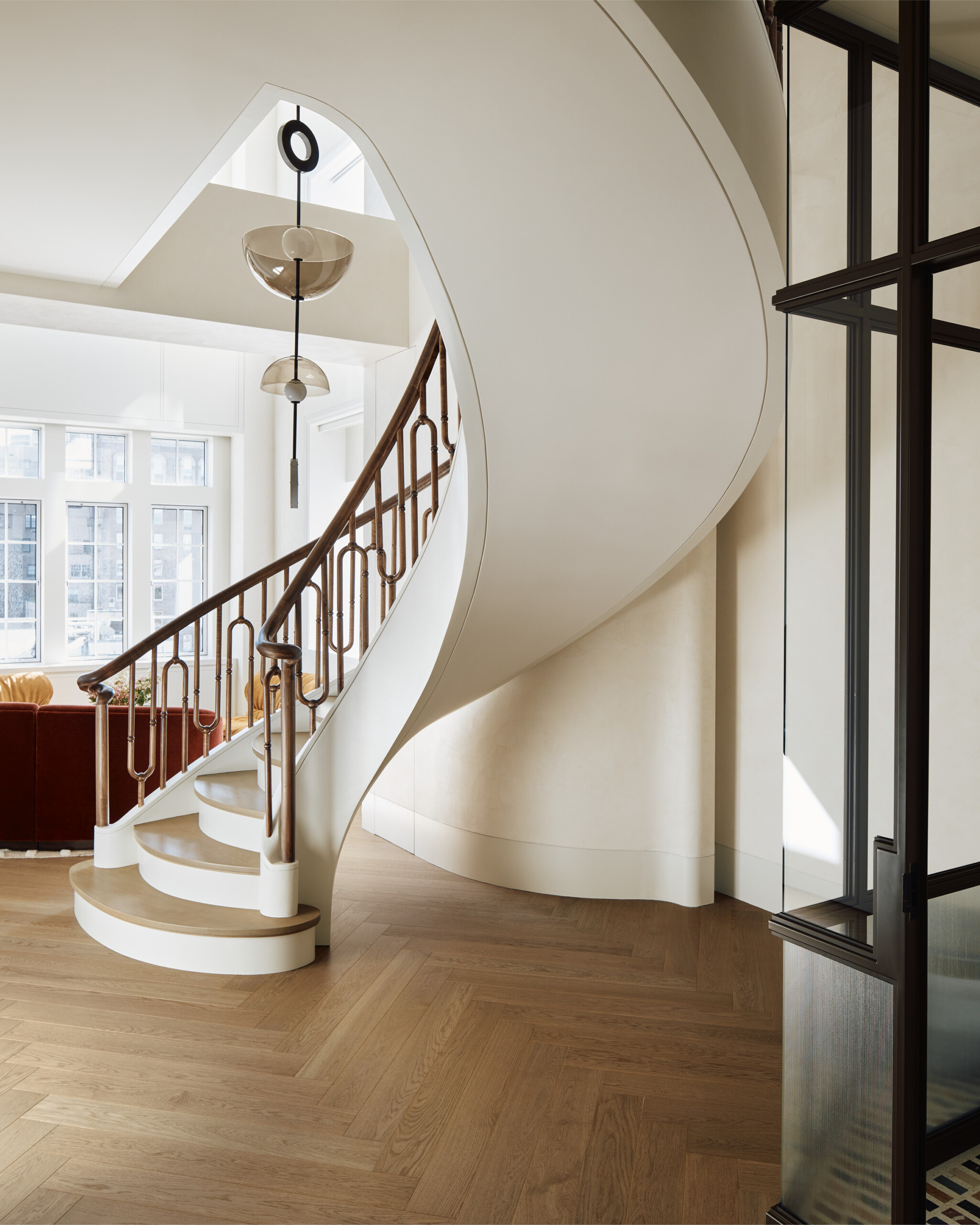 New York City interior design by Pembrooke & Ives. Foyer with glass partitian and spiral staircase.