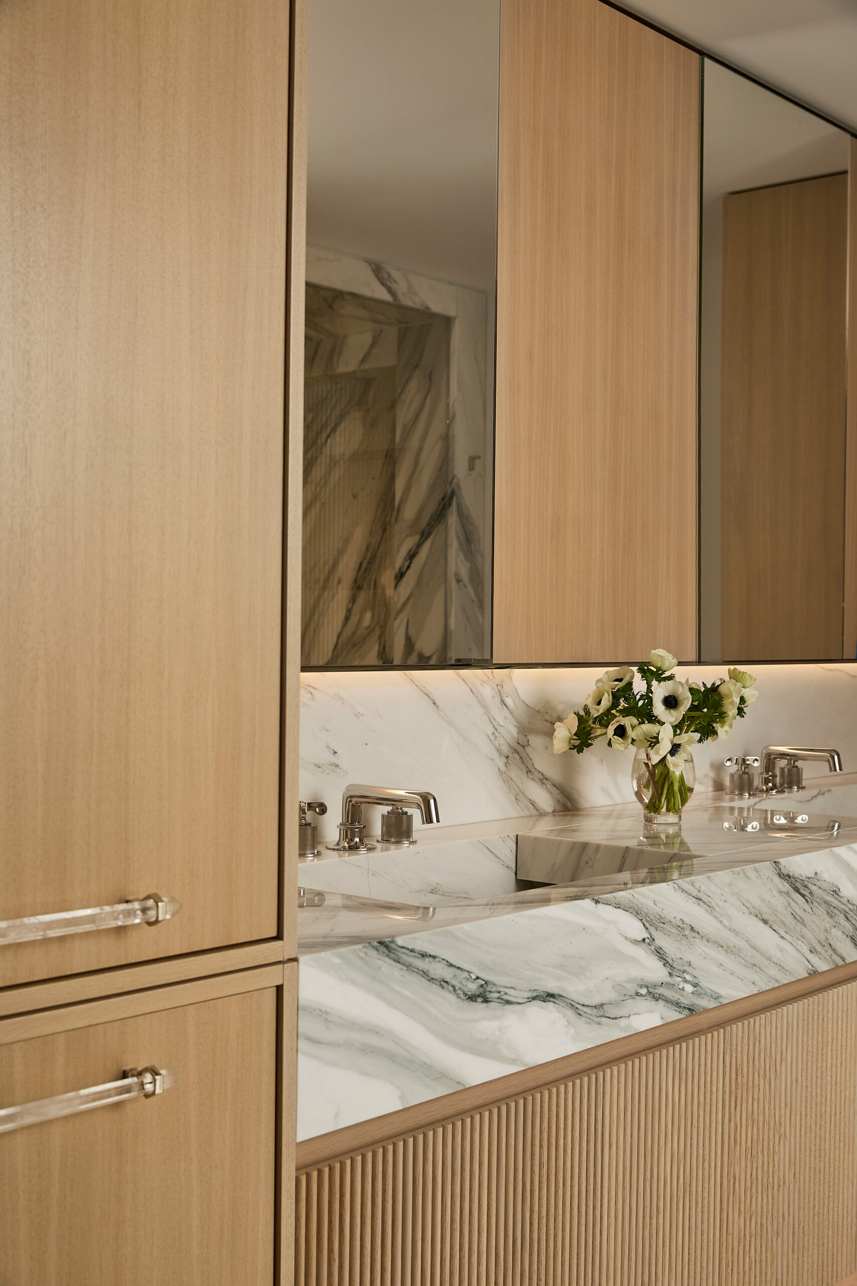 New York City Interior Design by Pembrooke & Ives. Primary bathroom with white oak cabinetry with...