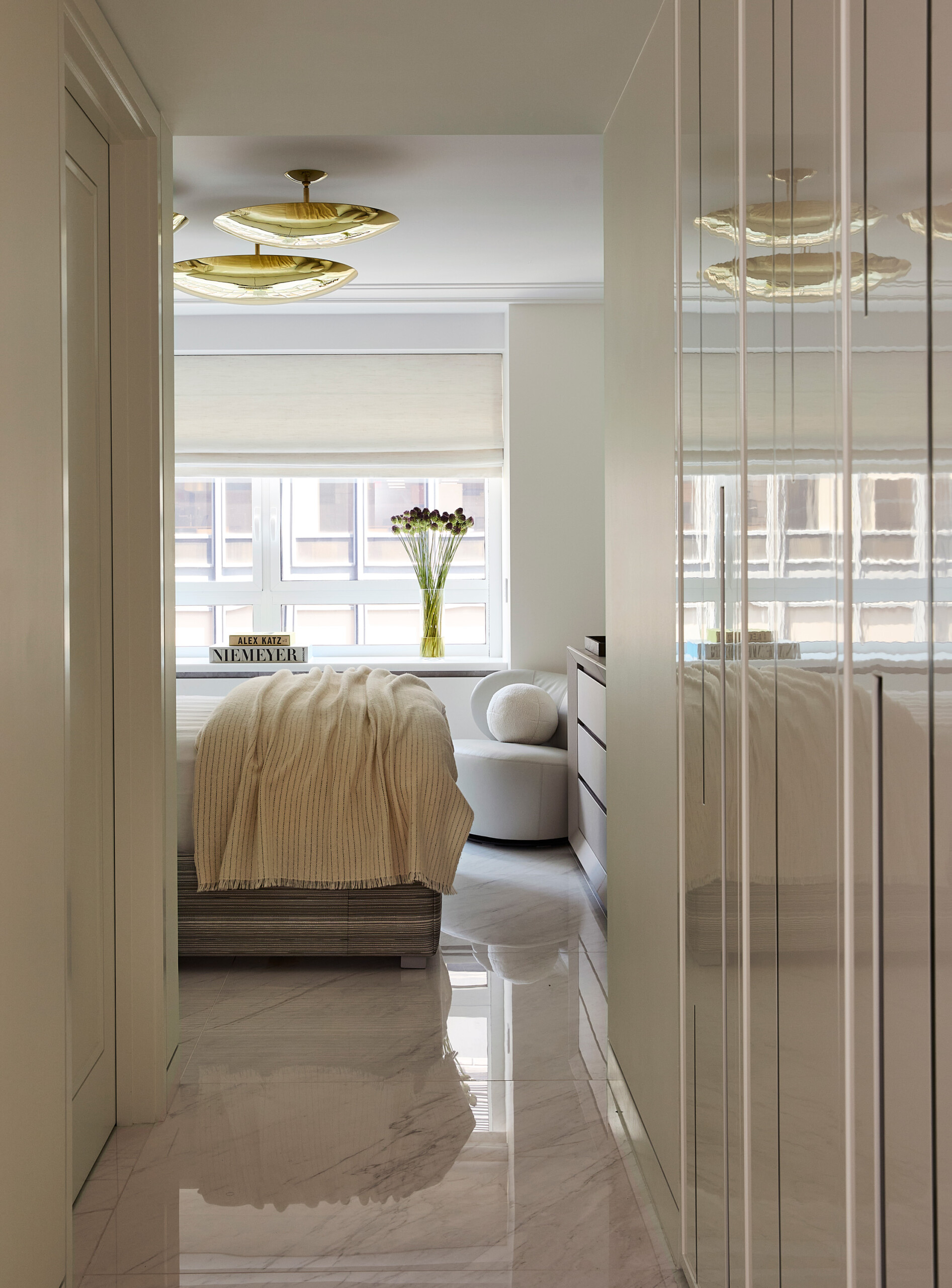 New York City Interior Design by Pembrooke & Ives. Neutral bedroom with glossy millwork storage...