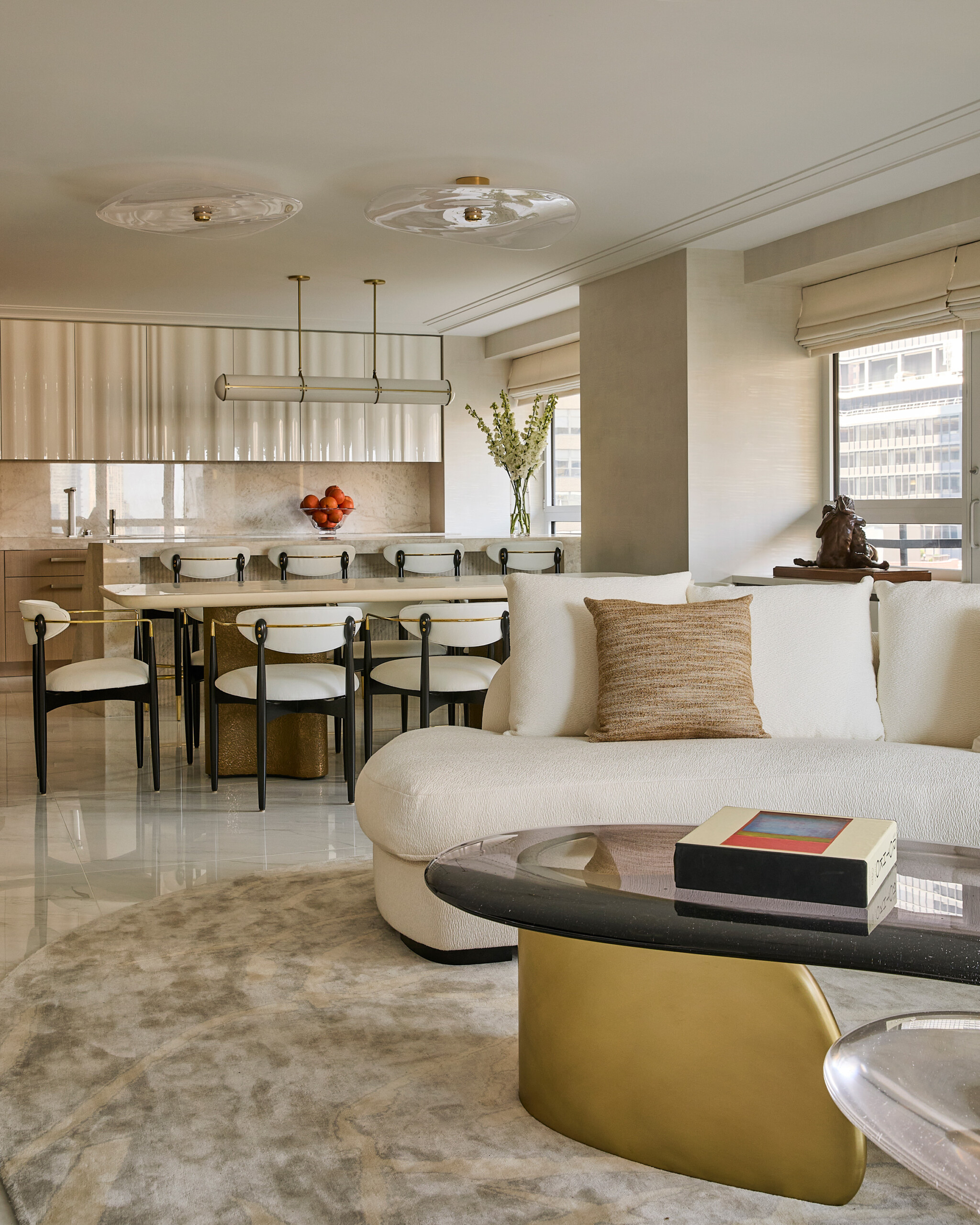 New York City Interior Design by Pembrooke & Ives. Warm neutral living room with kitchen and open...