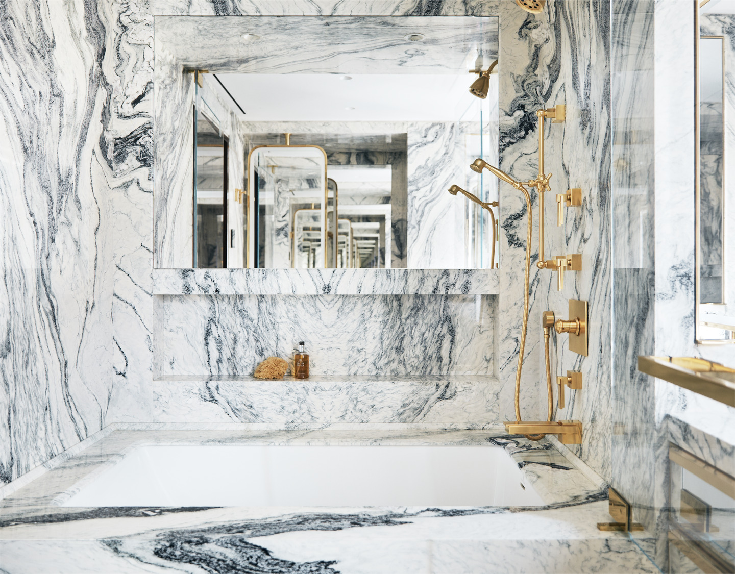 New York City interior design by Pembrooke & Ives. Primary bathroom with marble, a built in tub...